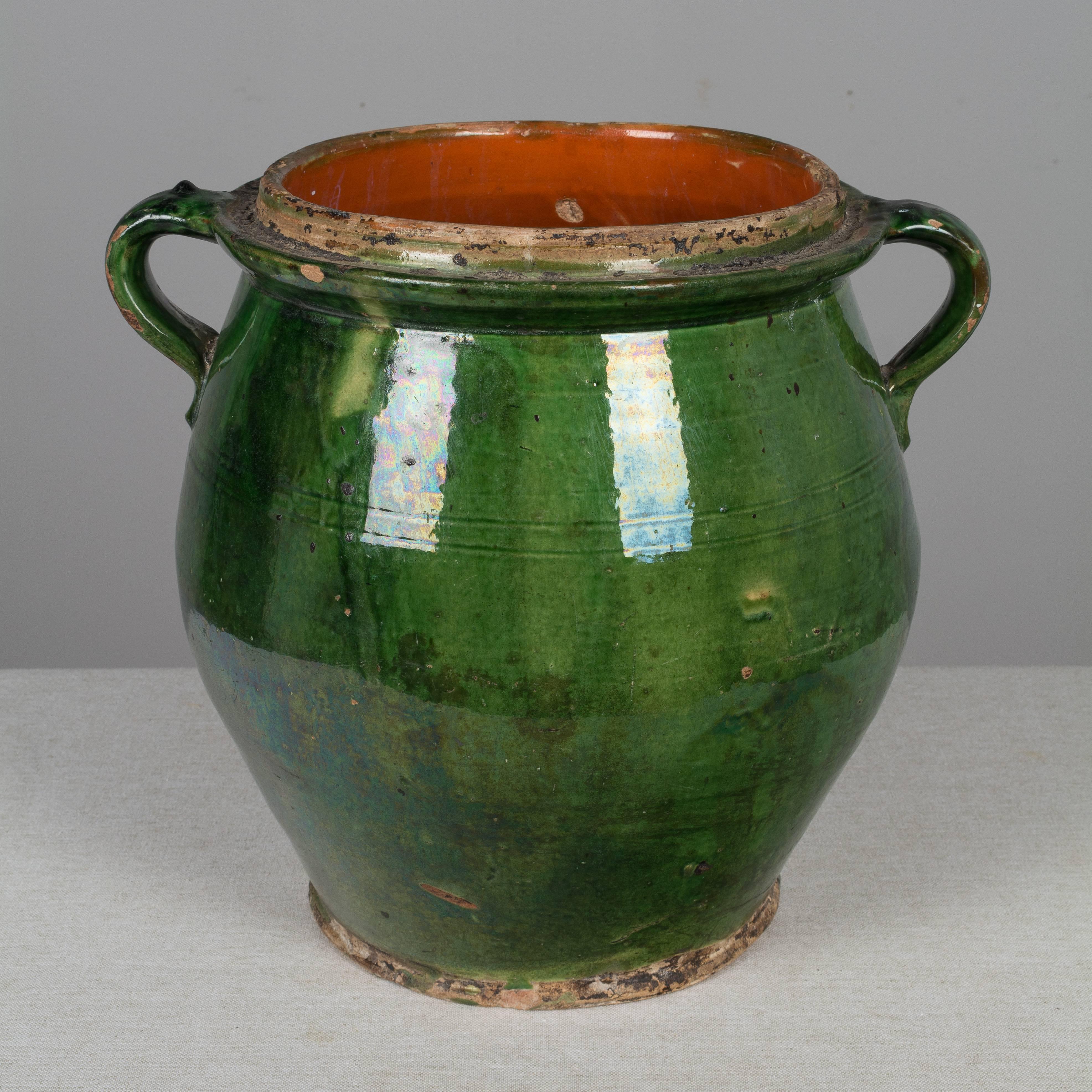 A large 19th century French terracotta two-handled pot with a beautiful emerald green glazed exterior and a rich terracotta glazed interior. In very good condition with a few chips. Weight: 11 lbs. Please refer to photos for more details. We have a