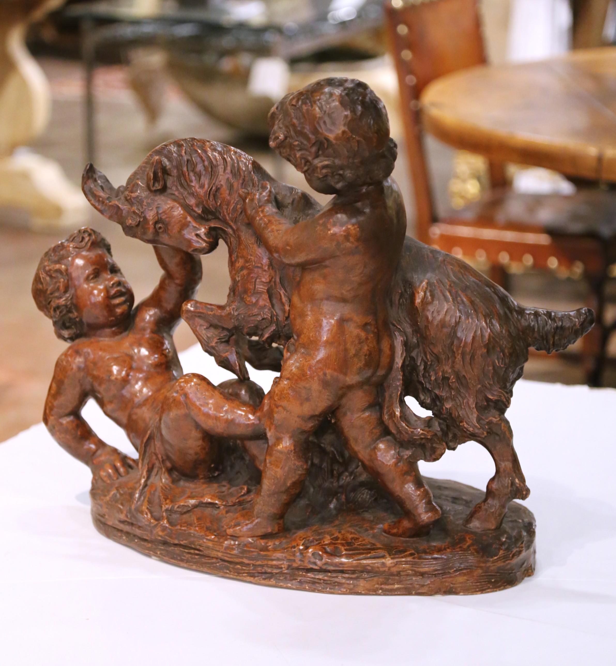Questa deliziosa scultura antica è stata realizzata in Francia intorno al 1890 e raffigura due bambini cherubini che giocano con una capra in una composizione gioiosa e animata. Scolpito in argilla e firmato sulla base P. de Leonardi, il pezzo