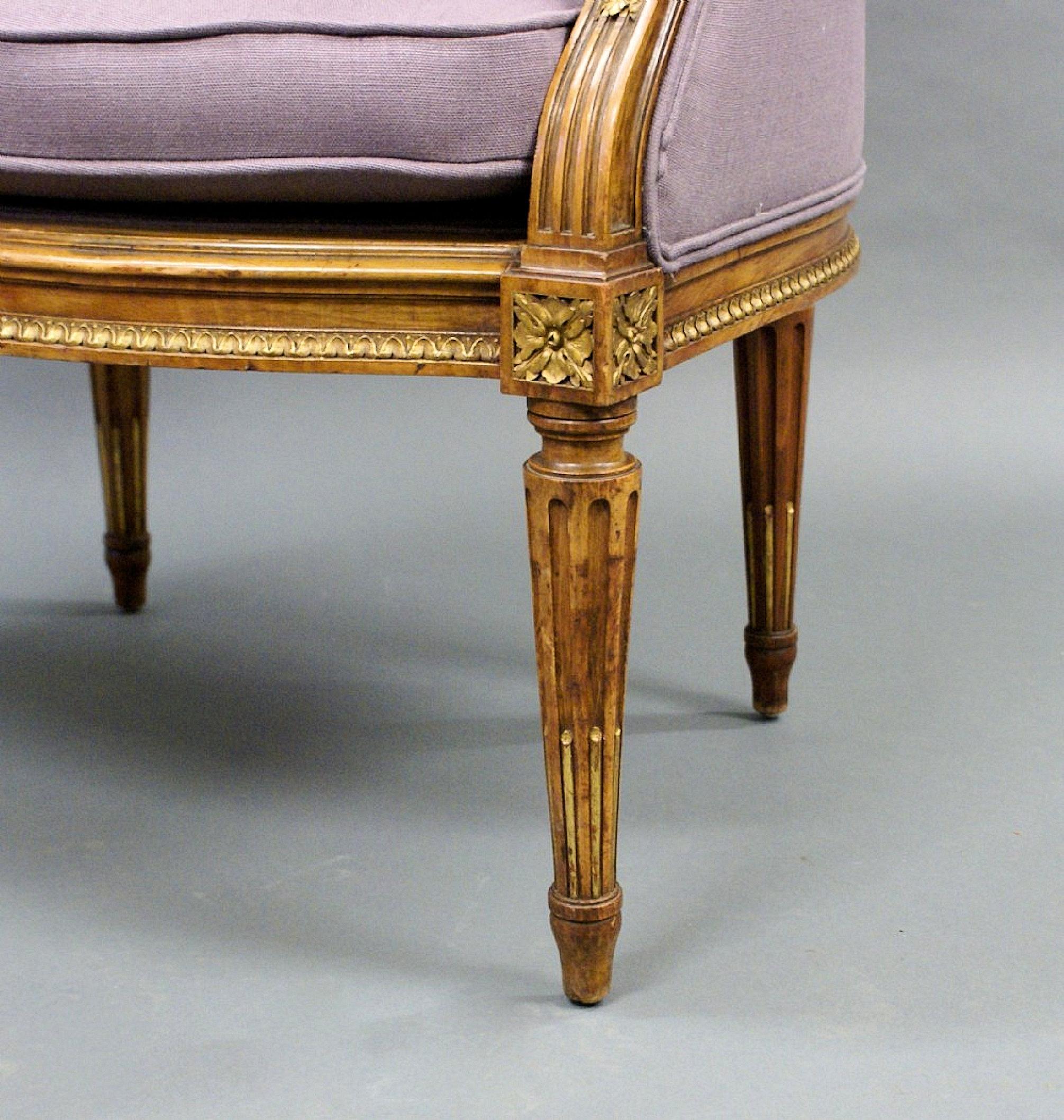 This gorgeous and very comfortable 19th C. French armchair is supported on turned and fluted legs, with a carved moulding around the outer frame. The chair has recently been reupholstered in a soft pale lilac linen blend fabric, but retains the