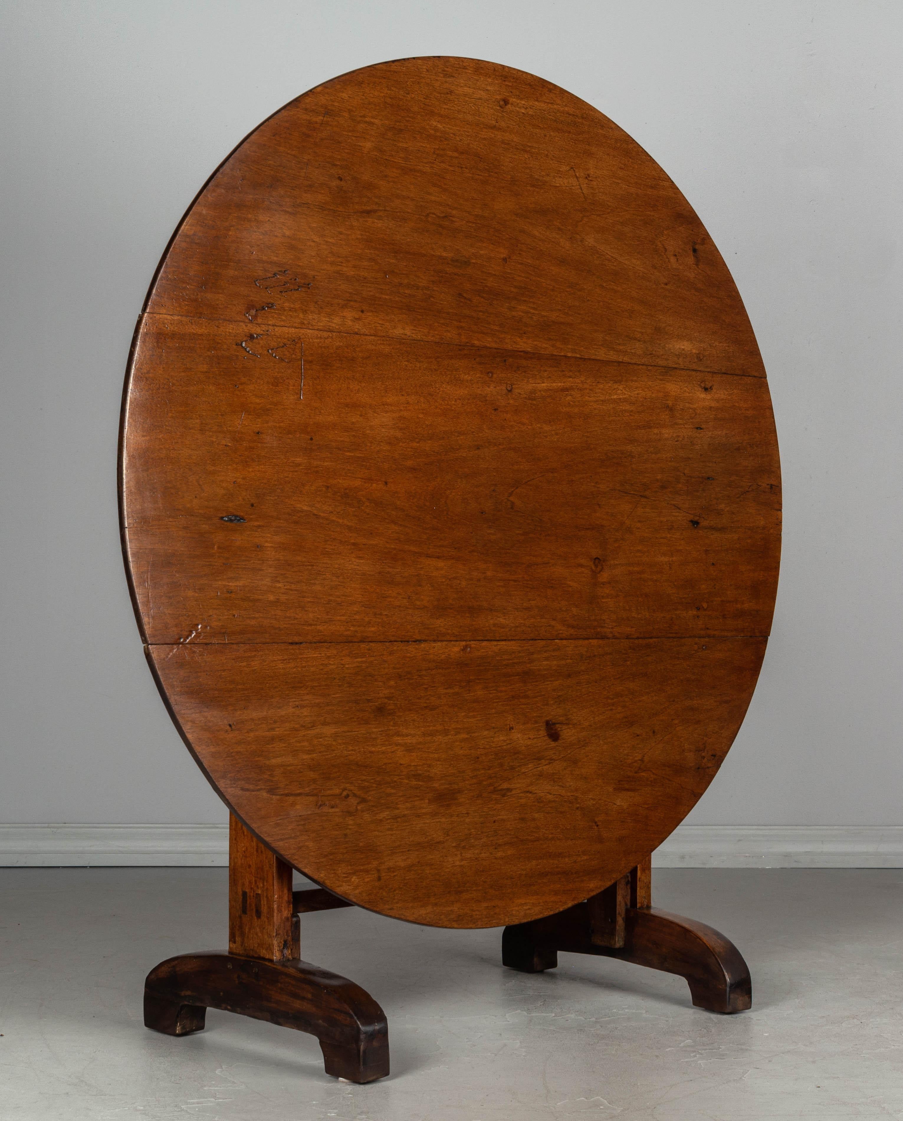 A 19th century French wine tasting, or tilt-top table, made of solid walnut. The top is made from three planks of walnut and the base is thick and sturdy. Well-crafted with mortise and Tenon joints and pegged construction. The feet have been