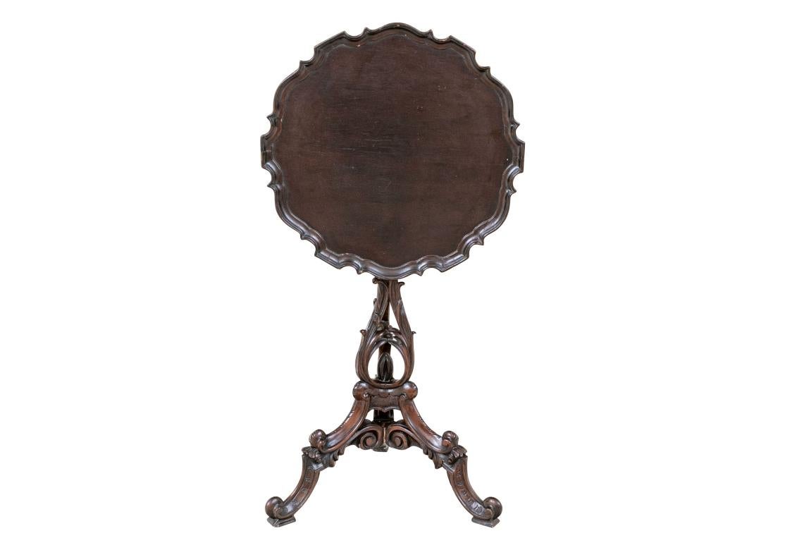 A small scale useful sized side table with bird cage mechanism for the tilt top. Raised on an elaborately carved three part tripod base with leaves and scrolled lower legs and feet. 

Dimensions: H. 33