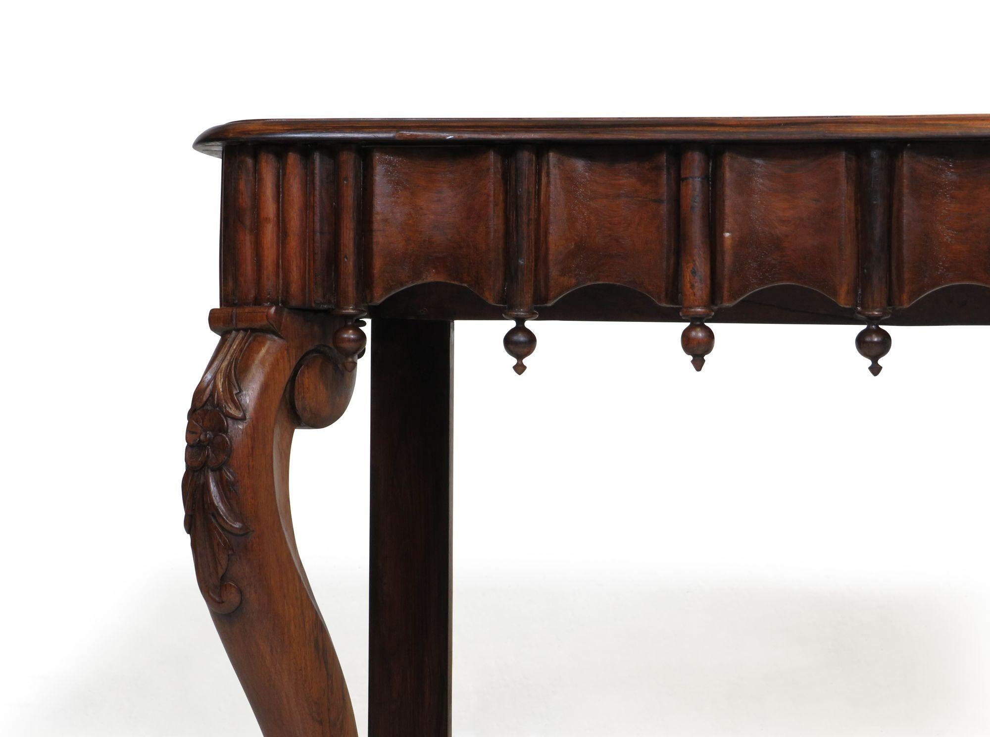 Exquisite 1850's Gothic revival console table handcrafted of richly figured solid Brazilian Rosewood with scalloped edge, decorative carved finials, florets and paw feet. 
 
W 55.50 x D 22 x 34.50 
Top surface depth 20.75