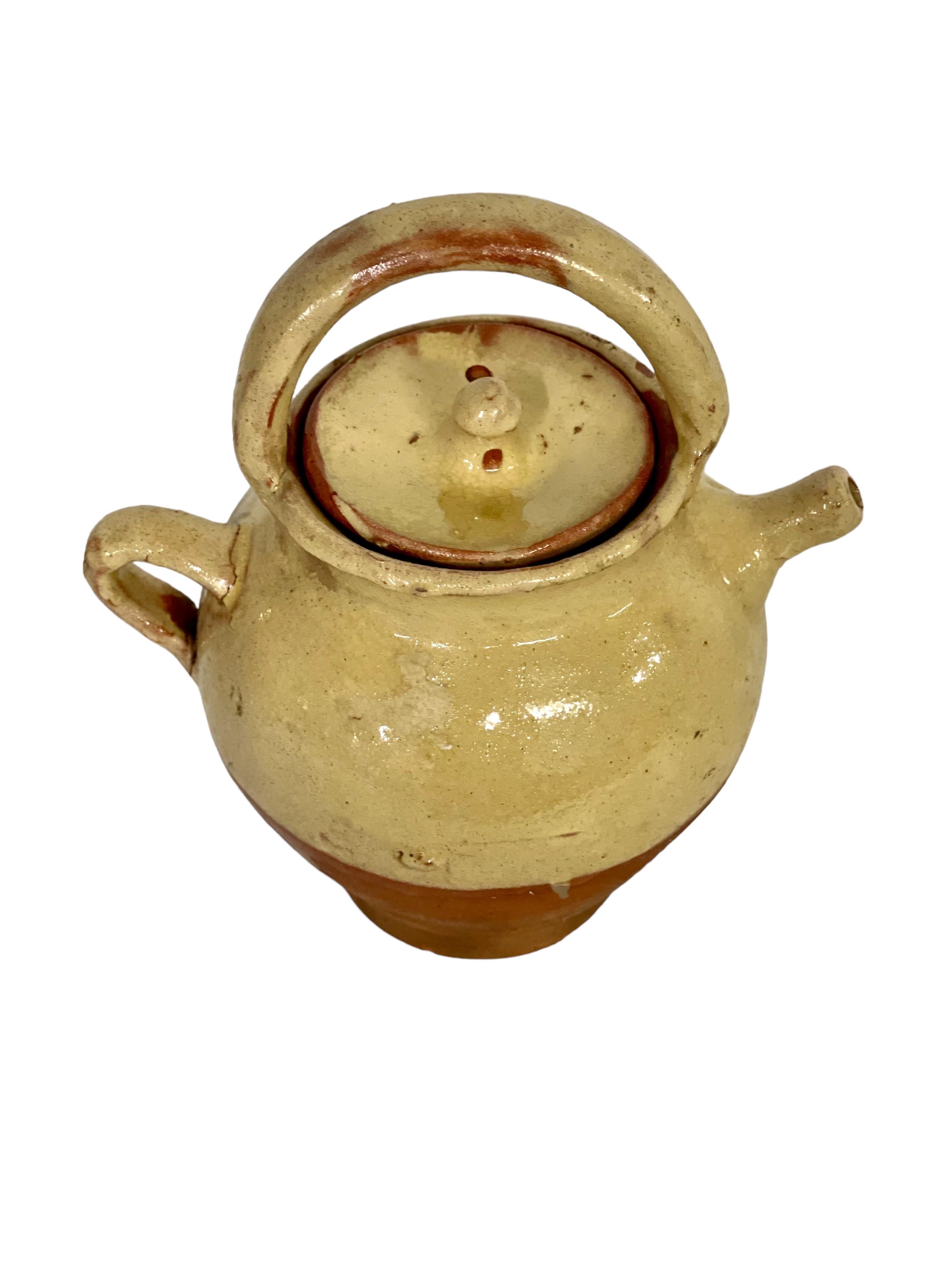 A petite and very charming half-glazed water cruche, with side and top handle, spout and original lid. It would have originally been used to transport water to workers in the farm fields, keeping it cool and clean ready for drinking. Vessels that