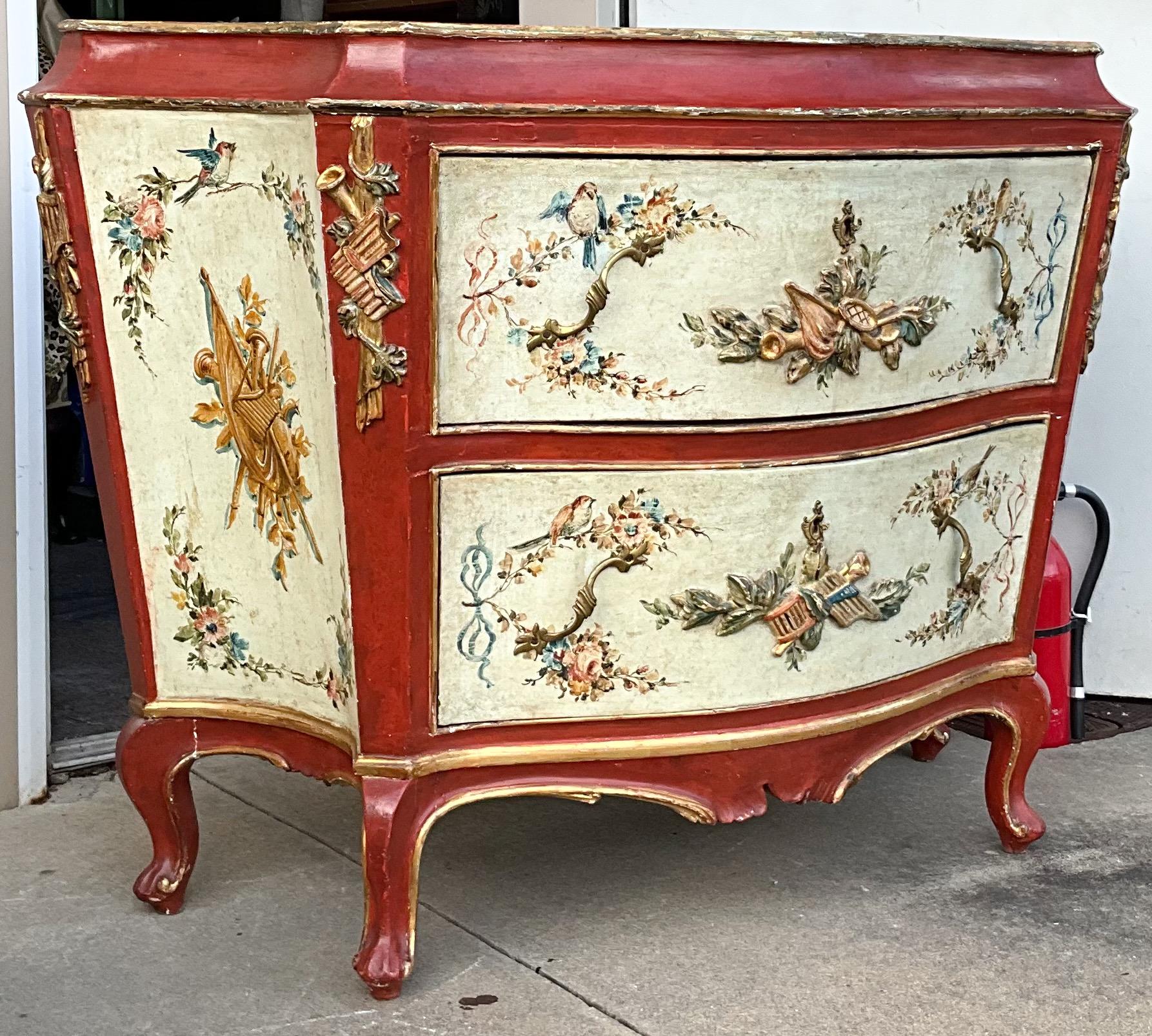 This is a breathtaking 19th century Venetian Rococo style commode. It is hand painted and beautifully done. The piece depicts birds, ribbons and instruments as well as floral swags. It is in very good antique condition.