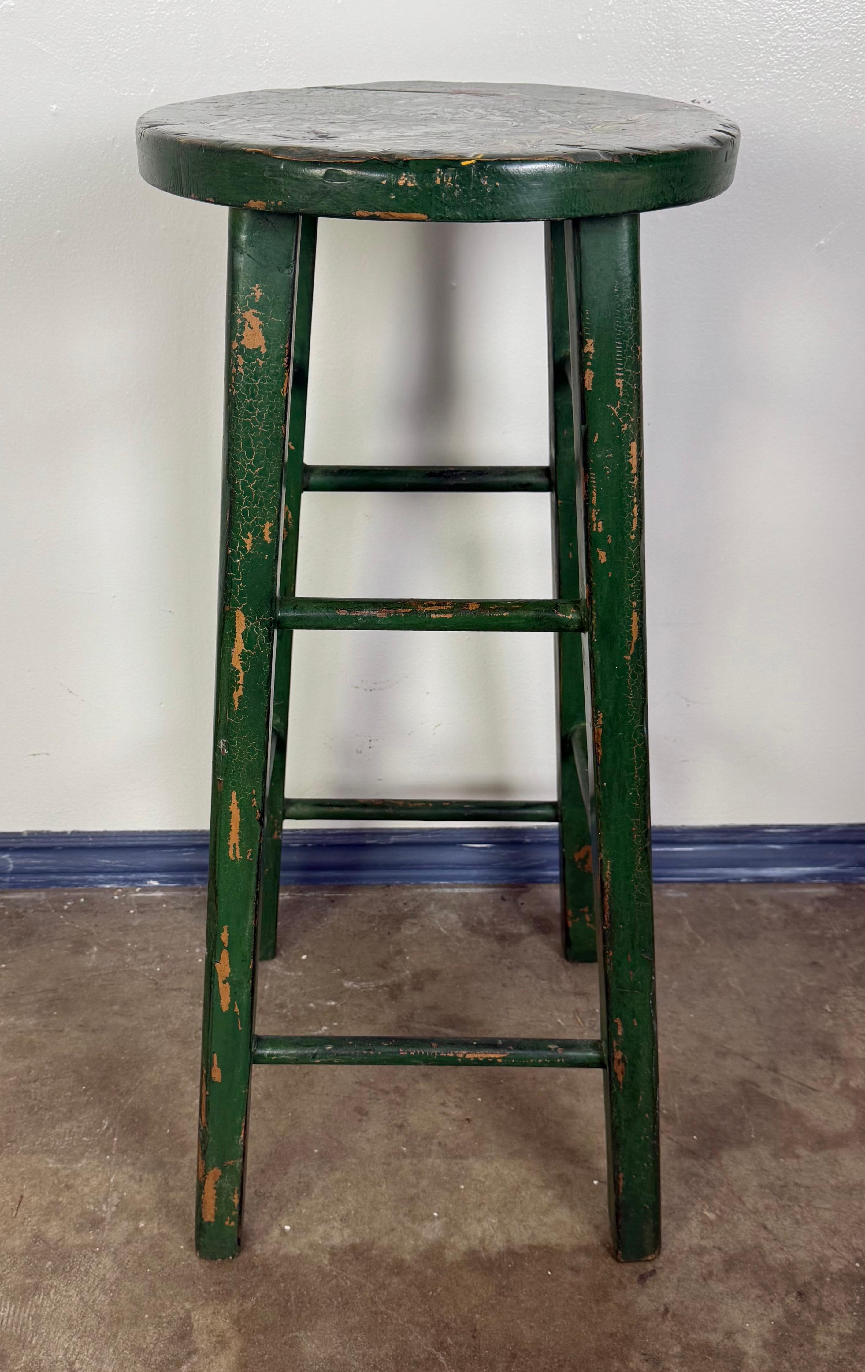 Este encantador taburete pintado de estilo rústico francés presenta un acabado verde rústico con auténtico desgaste que realza su atractivo vintage. El asiento redondo está pintado a mano con una animada representación de un gallo en blanco y negro