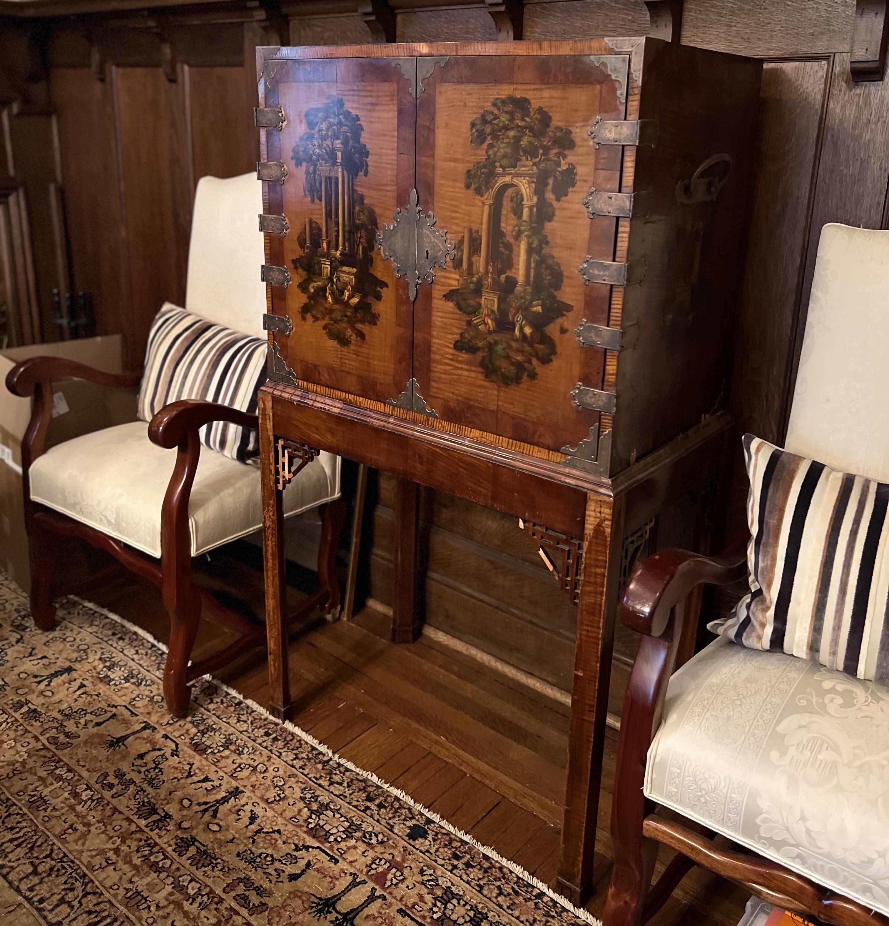 A visually commanding and richly detailed 19th-century Continental japanned cabinet on stand, likely of Austrian or southern German origin, lavishly painted with architectural vignettes and floral compositions. This romantic and historically