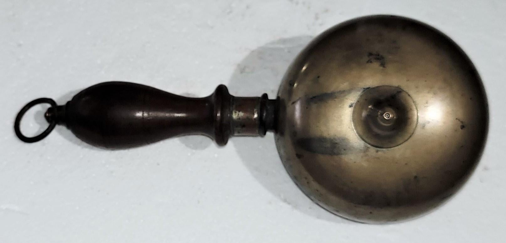 Seltene handgehaltene Muffin-Glocke aus dem 19. Jahrhundert, die den Feueralarm ausruft. Die Glocke besteht aus zwei Messingkuppeln, die Rücken an Rücken mit Eisen montiert sind, einem gedrechselten Holzgriff und einem Messingring. Die Glocke wurde