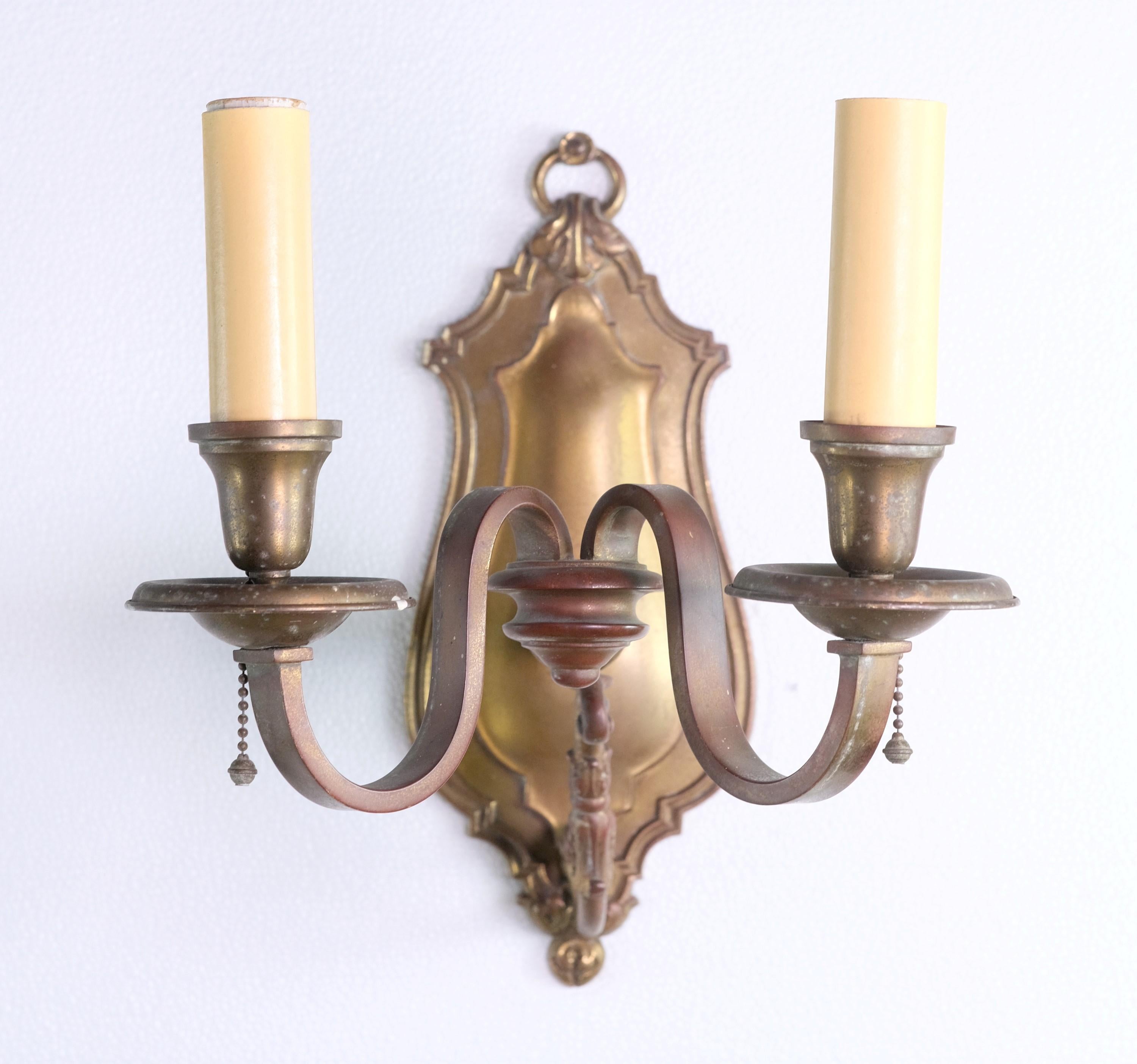 19th Century set of four bronze sconces with subtle foliage details and candlestick arms. They were reclaimed from The William Tilden Estate. There is a natural patina and are well preserved. Priced as a set of four. Price includes restoration.