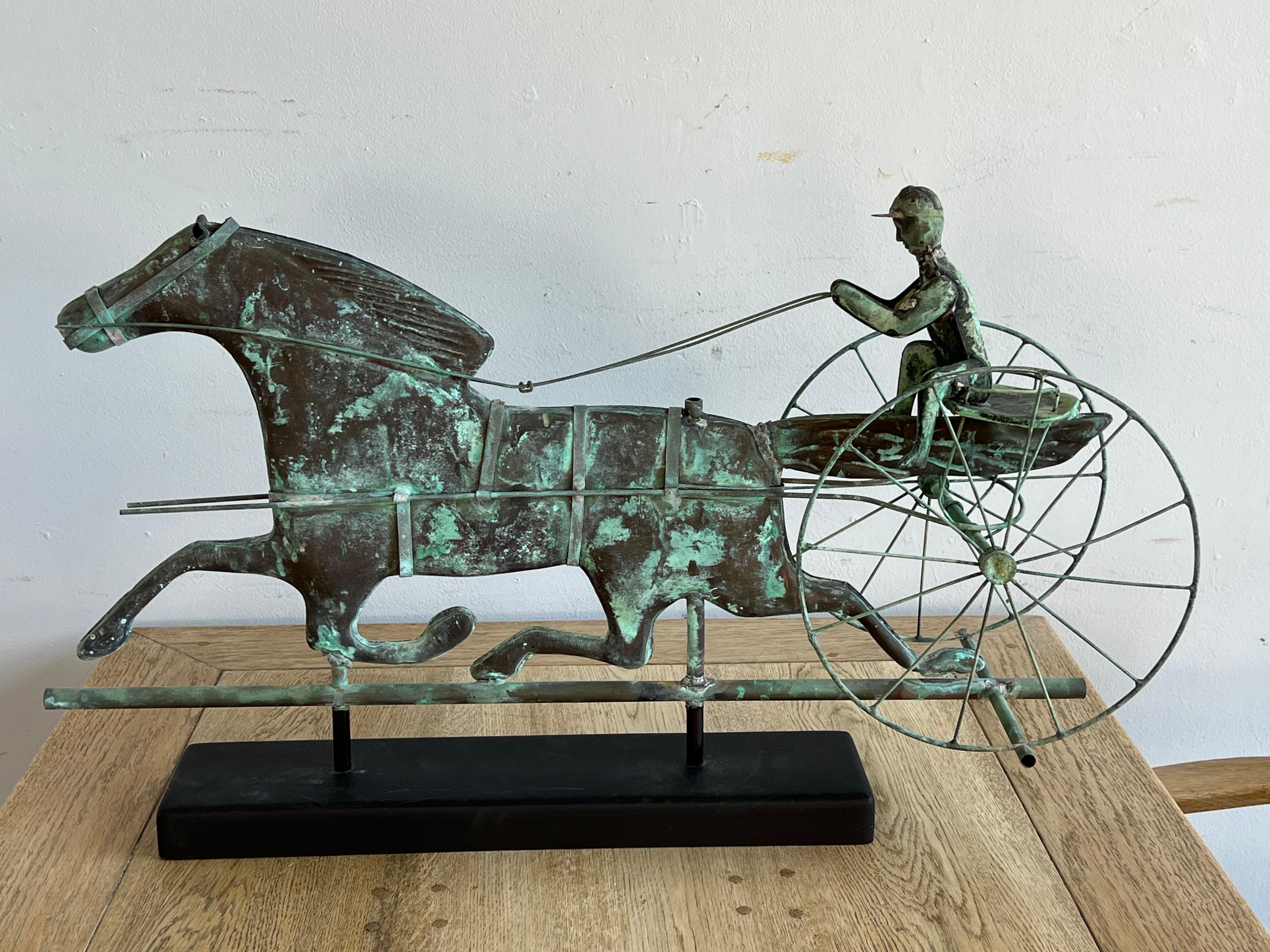 19th C. molded sheet copper horse and driver vane with cast iron horse's head and driver's hands, sheet copper reins and seat, copper rod wheels, mounted on a wood ebony colored base. The copper has developed a beautiful patina over the years