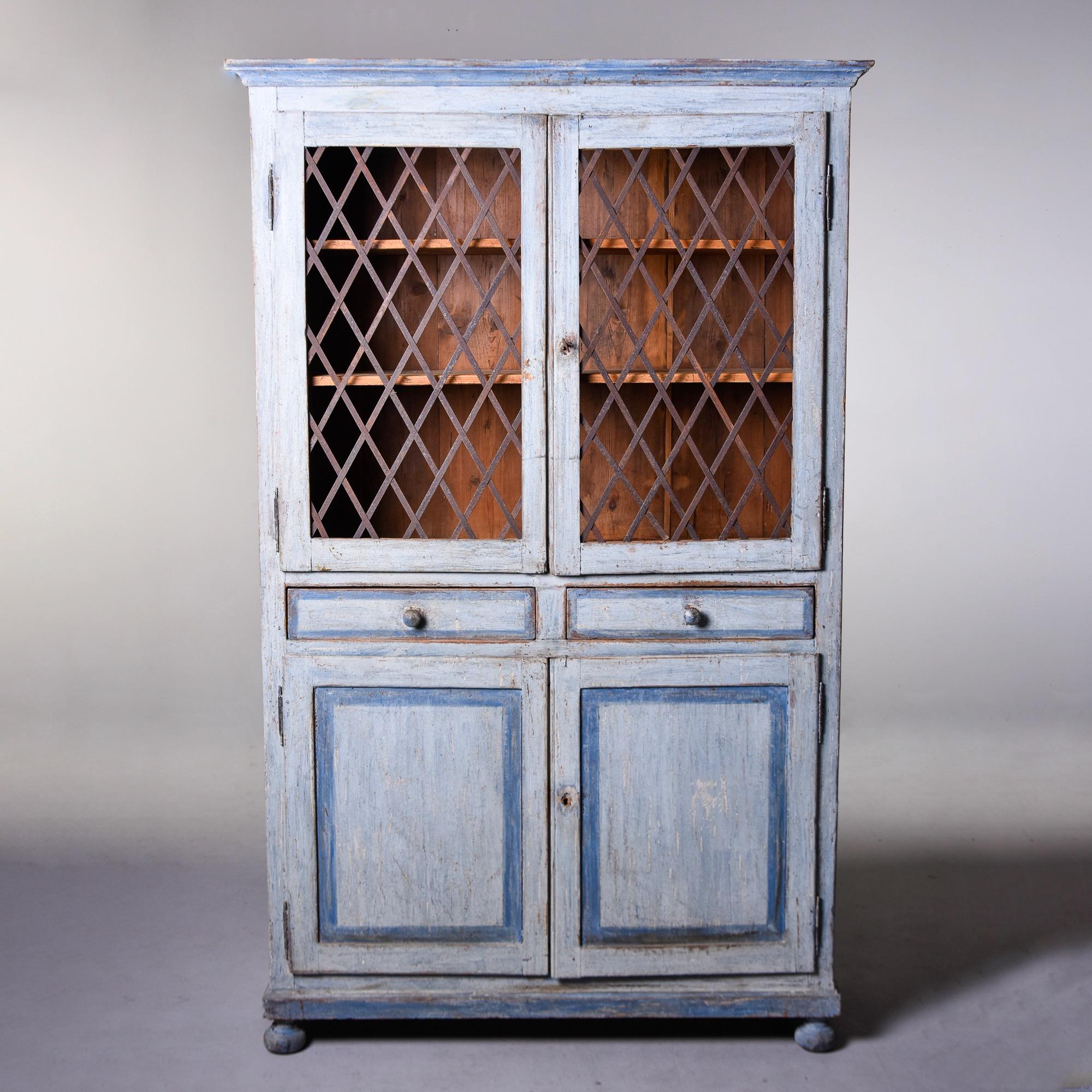 Found in Italy, this circa 1850s tall painted cabinet is from the Bologna region. Top section has a pediment top, functional lock with original key, unpainted interior and two adjustable internal shelves. Doors have weathered metal lattice fronts.