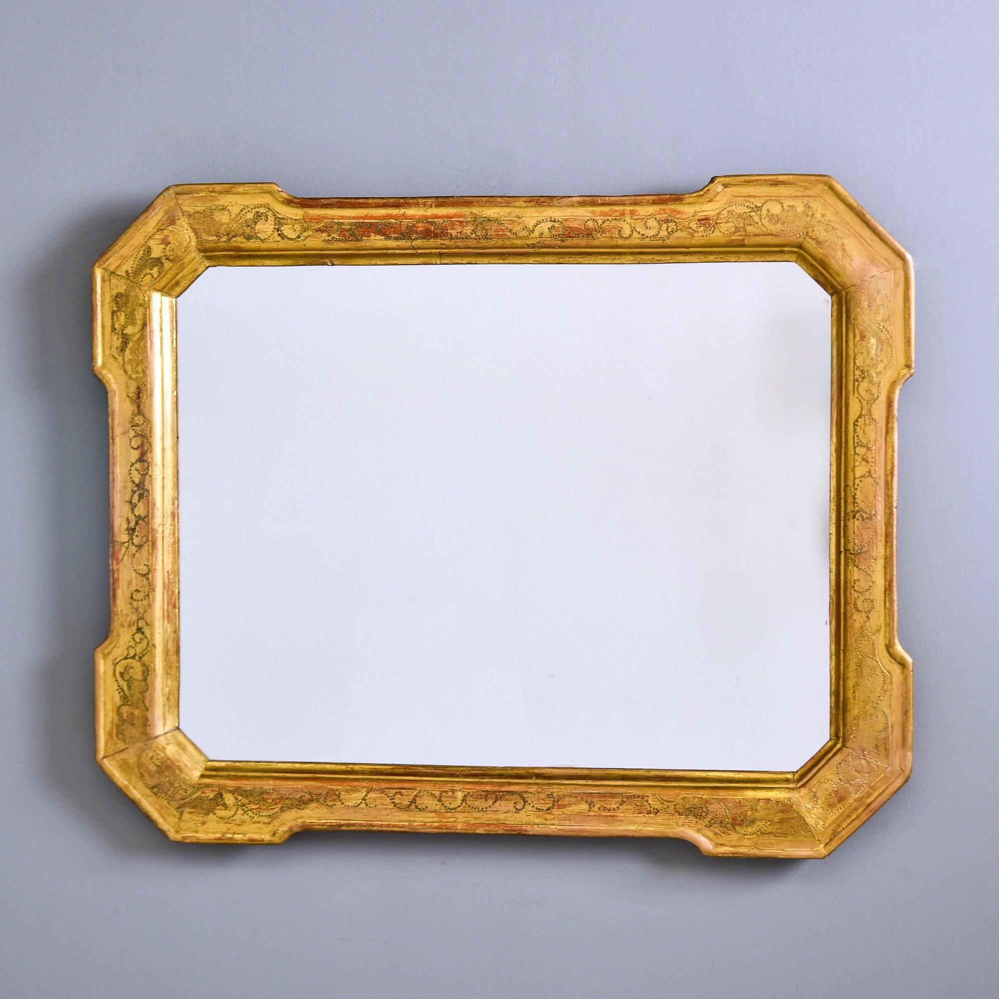 Trouvé en Italie, ce miroir au cadre doré date des années 1890. Le large cadre en bois doré est rectangulaire avec des coins fantaisistes et un motif gravé de style pointilliste sur tout le pourtour de la surface supérieure. Fabricant inconnu.