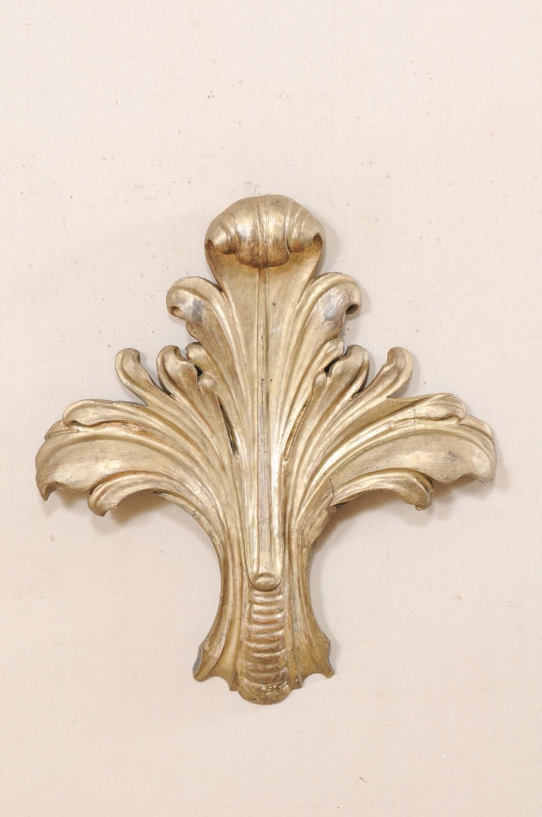 An Italian foliage carved-wood wall decoration from the 19th century. This antique wood wall hanging from Italy, standing approximately 33.5 inches in height, features a stylized hand carved acanthus plume with a curled tip and gently bowed side