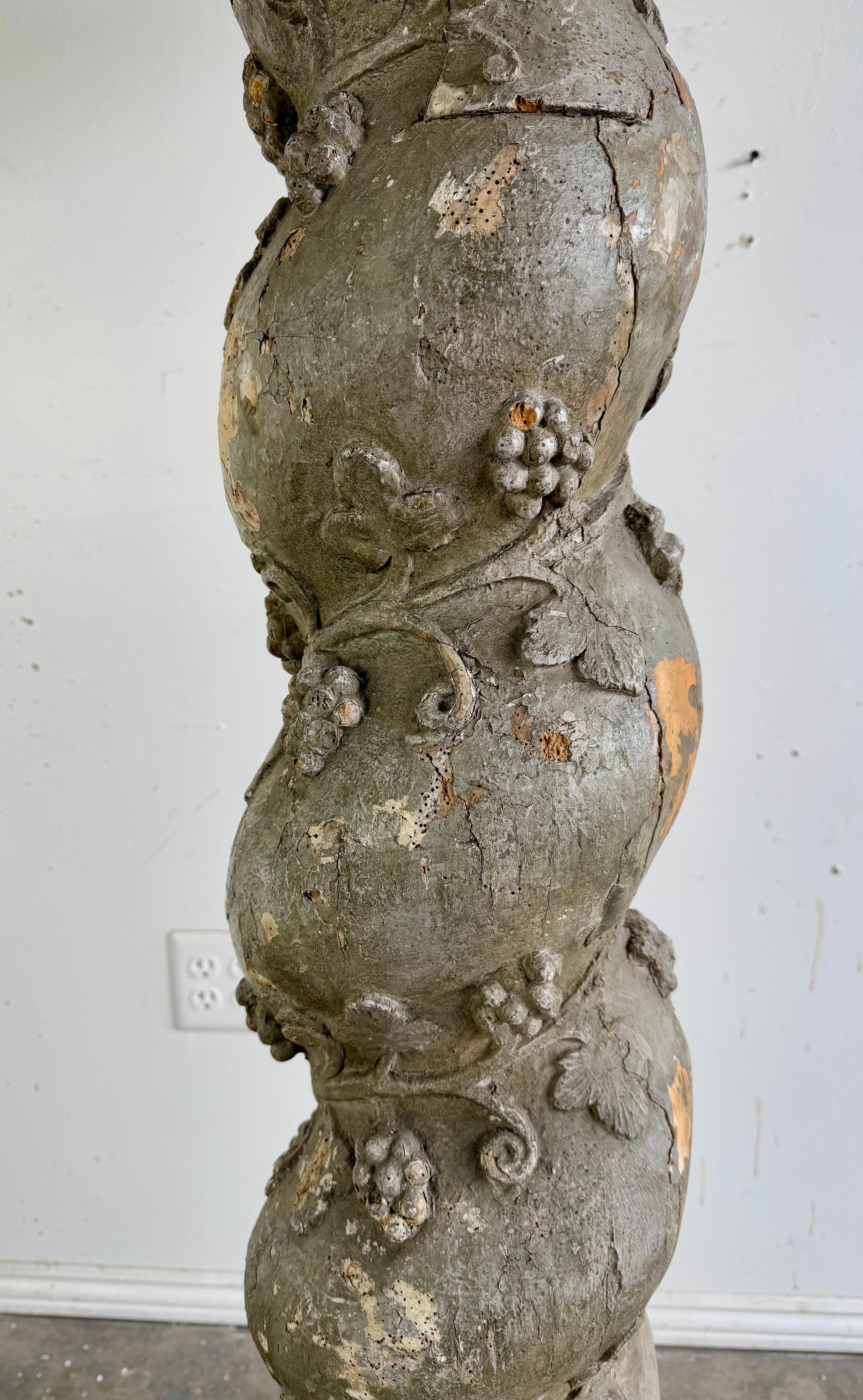 This is a large floor lamps with a 19th century highly decorative, sculptural base.  The base features a twisted spiraling column with a rustic, weathered finish.  The column is adorned with an intricate design of vines, leaves, and grape clusters,