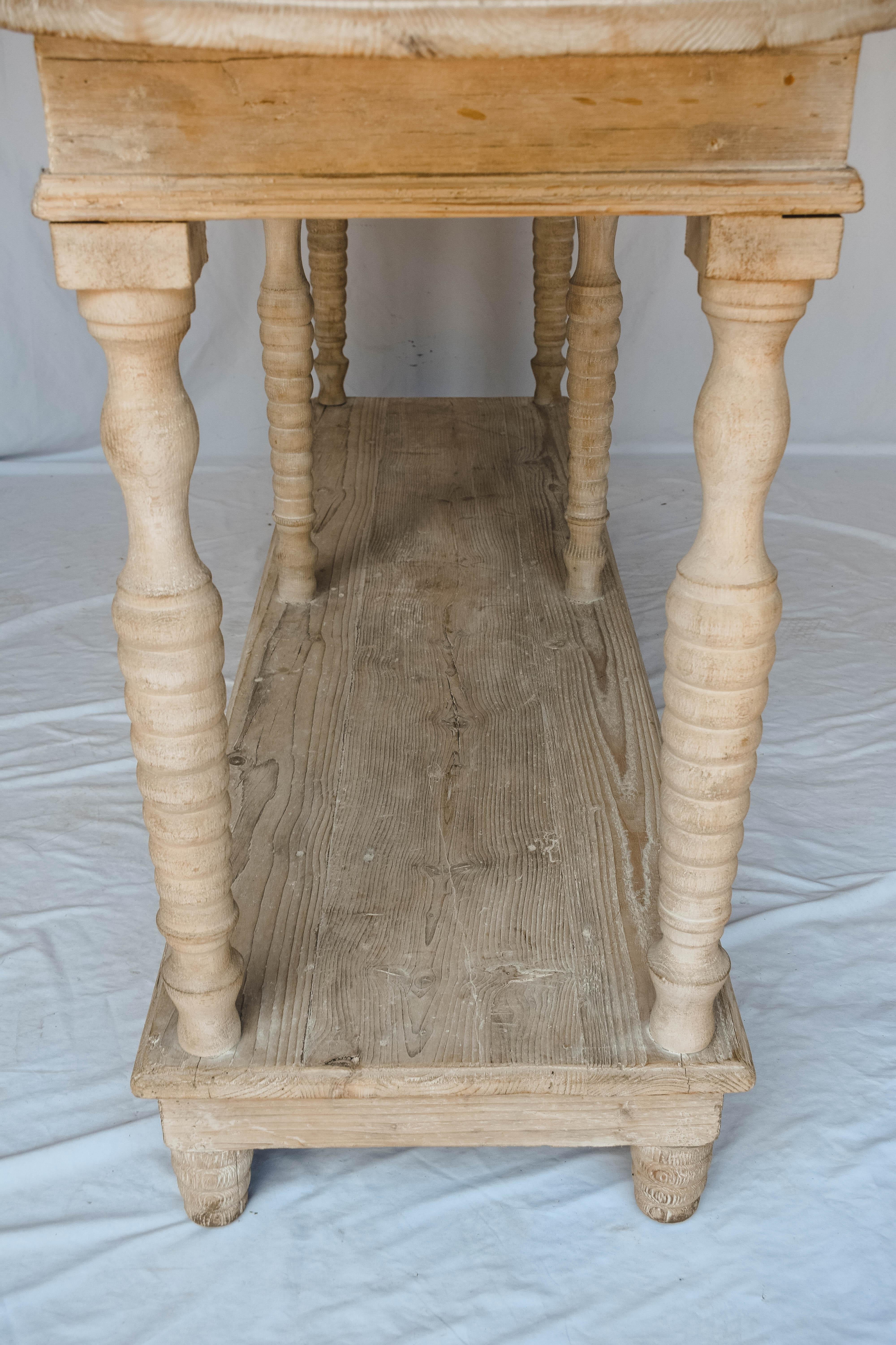 This 19th century console table in abete (fir) wood is a beautiful light white washed color. The legs on this table are turned and it has a second level perfect for storage. This would make a handsome addition to any family room paired with a couch