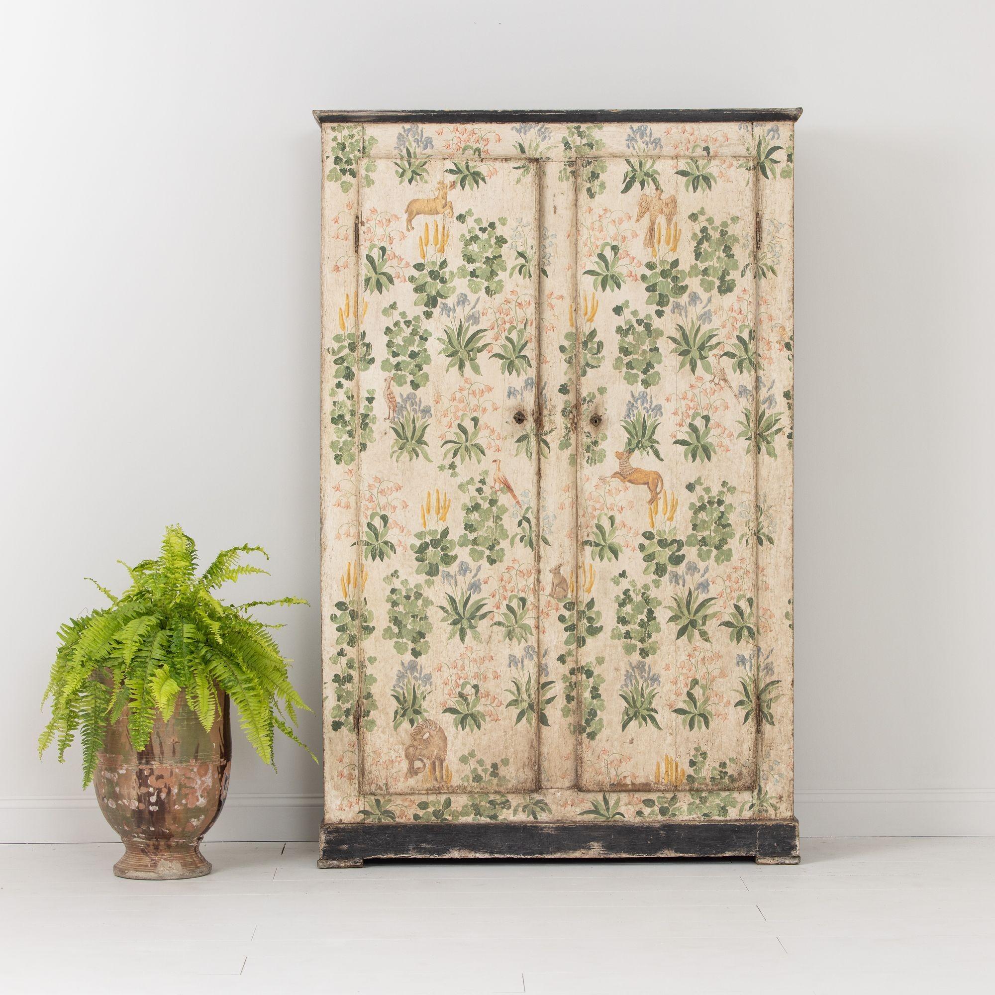 A Florentine armoire cabinet from the 19th century, Italy c. 1850. A beautiful, one-of-a-kind piece with hand-painted decoration inspired by an antique fabric fragment, featuring naturalistic animals and foliage throughout. A Maison & Co. favorite.