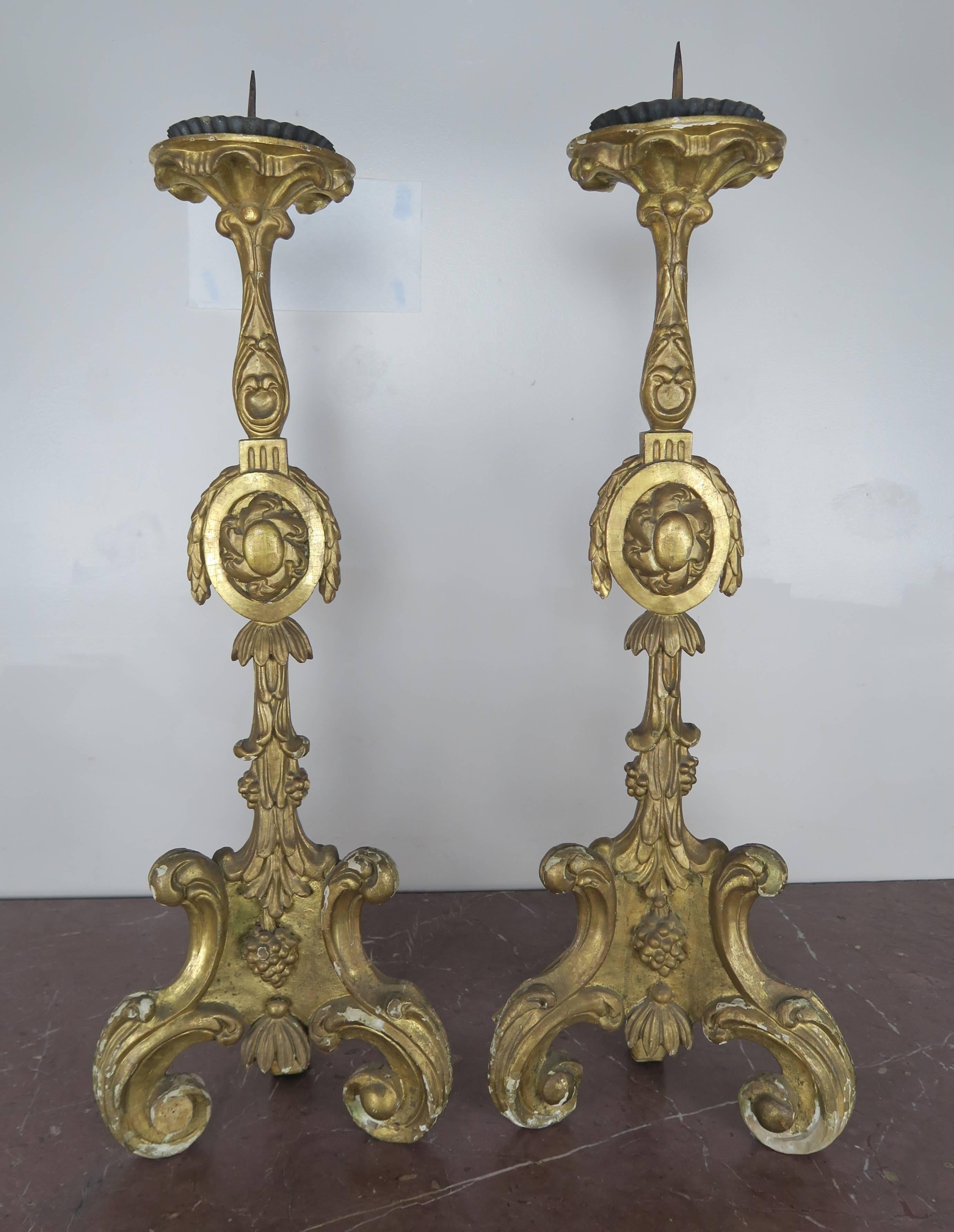 19th century Italian Baroque style giltwood altersticks with iron prickets and bobeches.