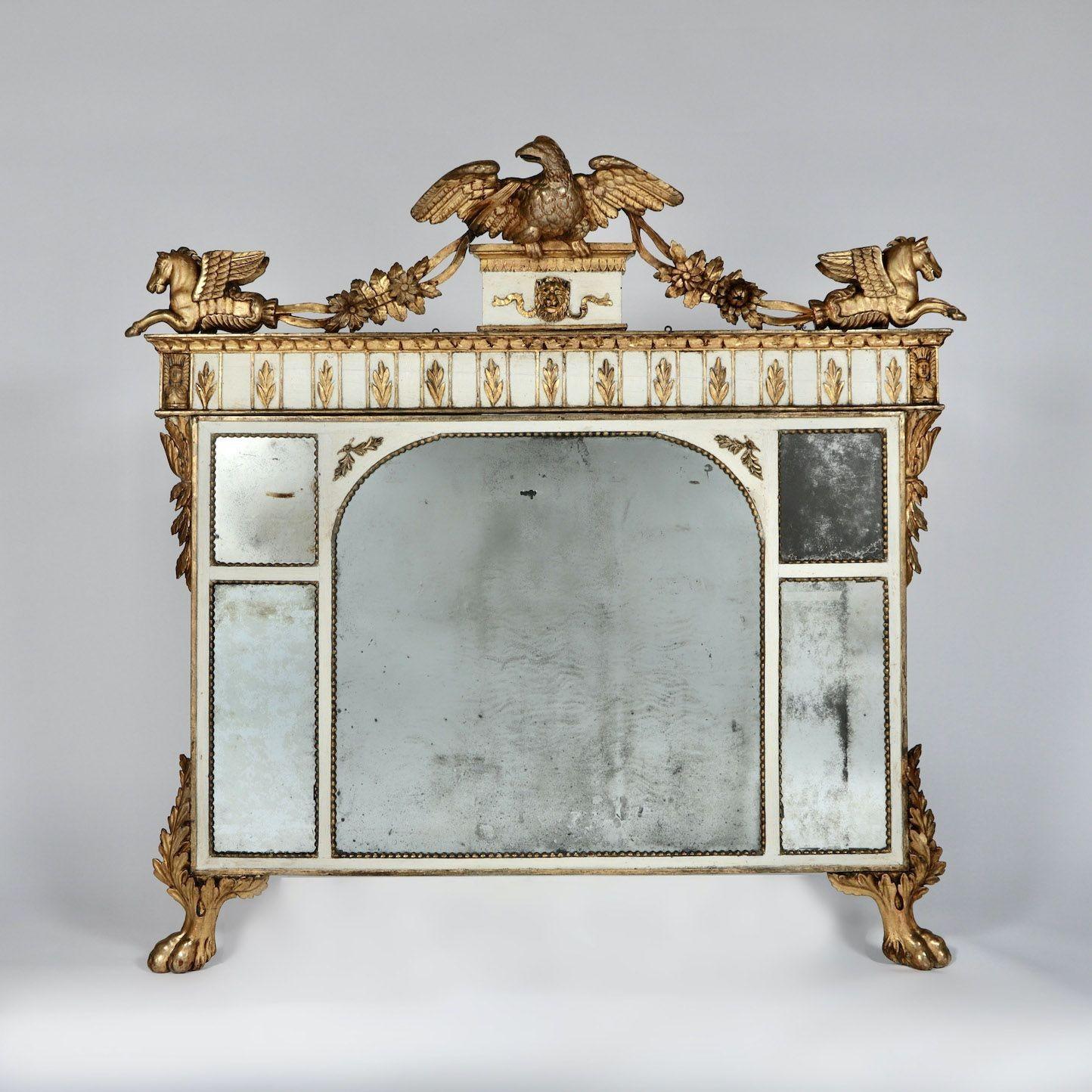A rare early 19th century Italian Neoclassical period, original giltwood mirror elaborately carved with inspiration from Ancient Rome, circa 1800.  The mirror plates are original and topped by a cresting of an eagle on a pedestal above a carved lion
