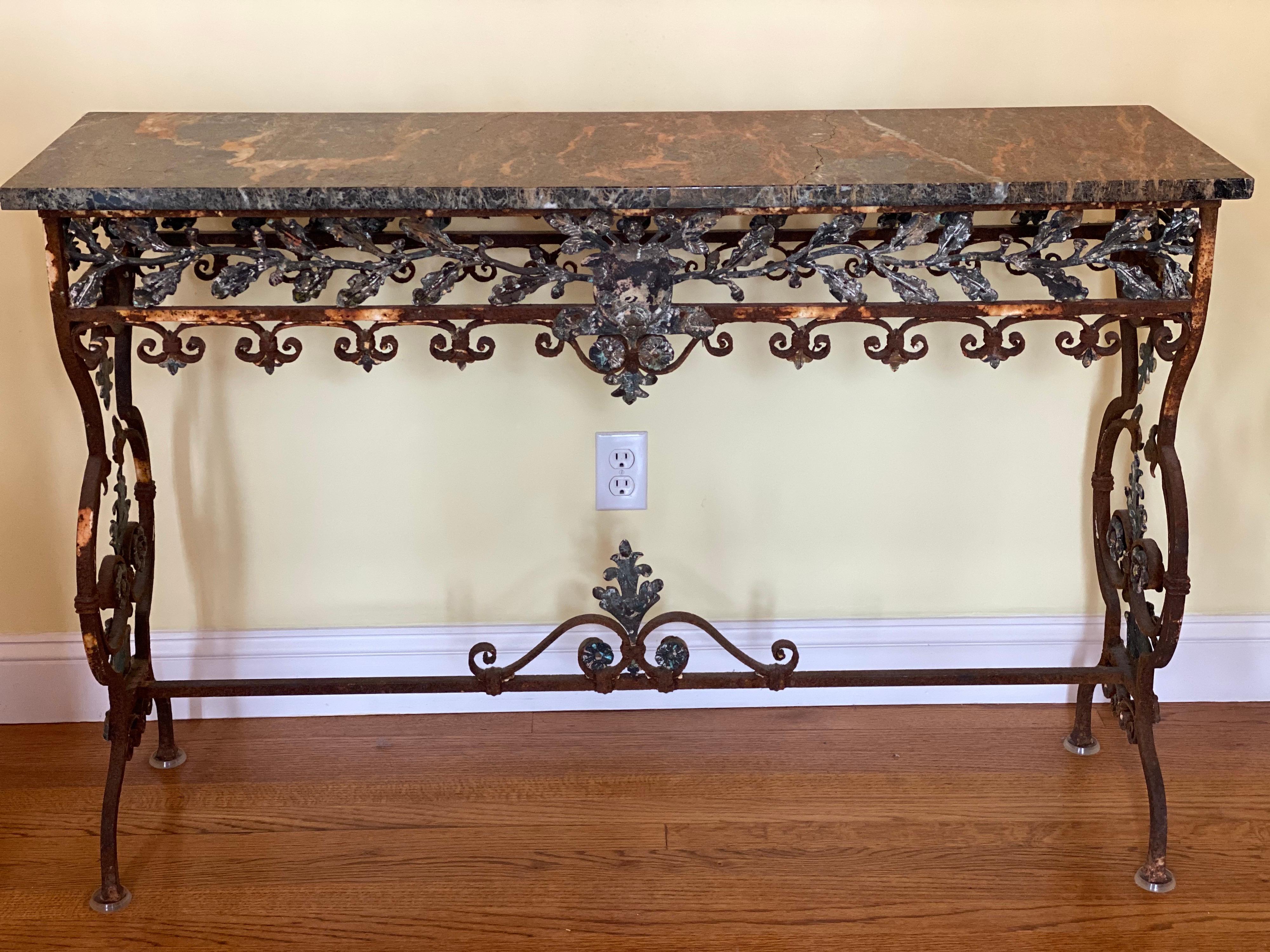 19th C. Italian iron console with oak leaf frieze and marble top. This is a stunning console has fine details including an oak leaf frieze, scrolling acanthus leaf details, beautiful aged patina and dark marble top. 
Condition: Crack in marble top,