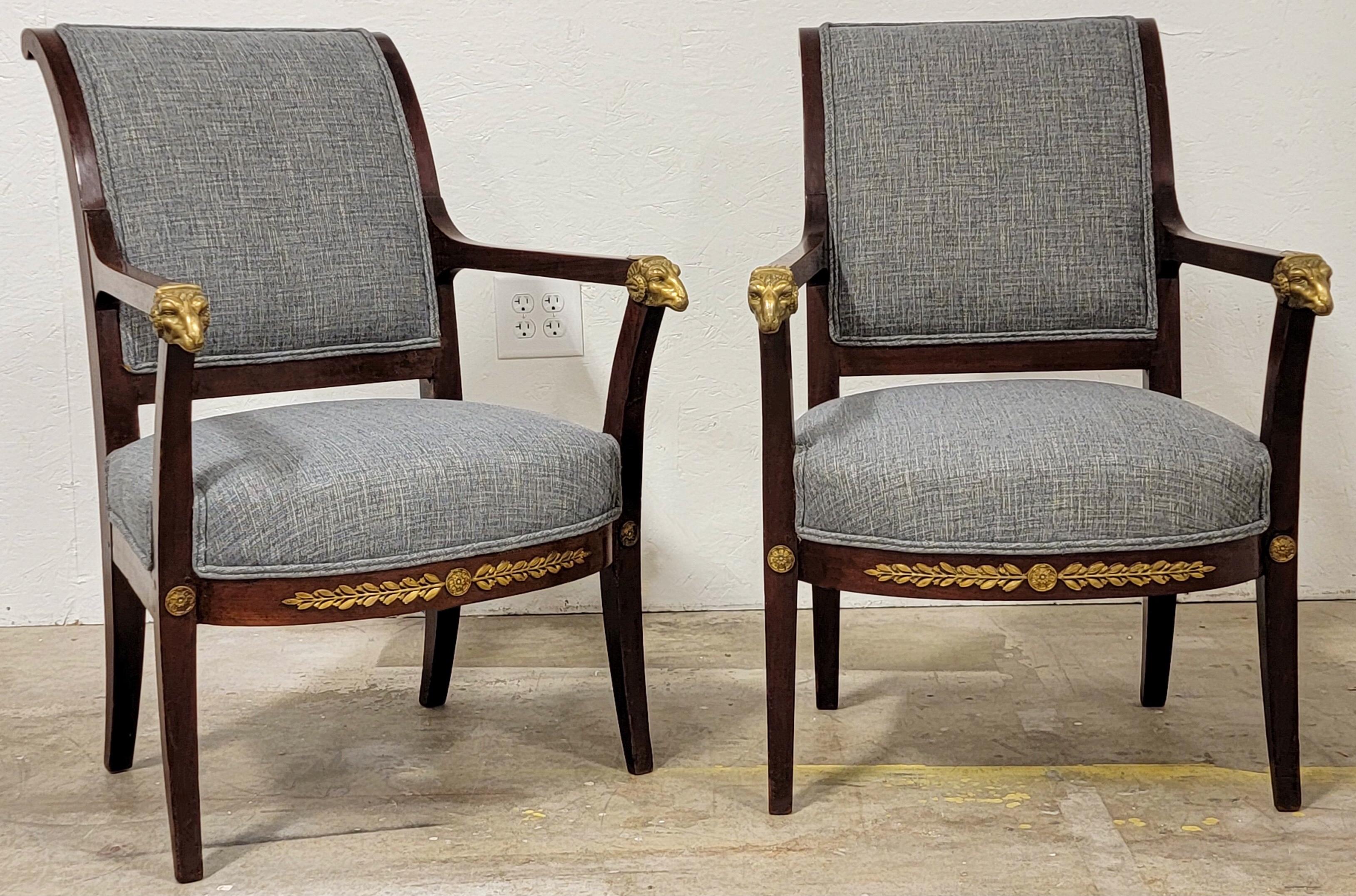 These are so elegant! This is a pair of late 19th century Italian neo-classical style arm chairs. The frame is a carved mahogany with peg construction. The grey linen blend upholstery is new. The star of the show is the bronze rams at the end of the