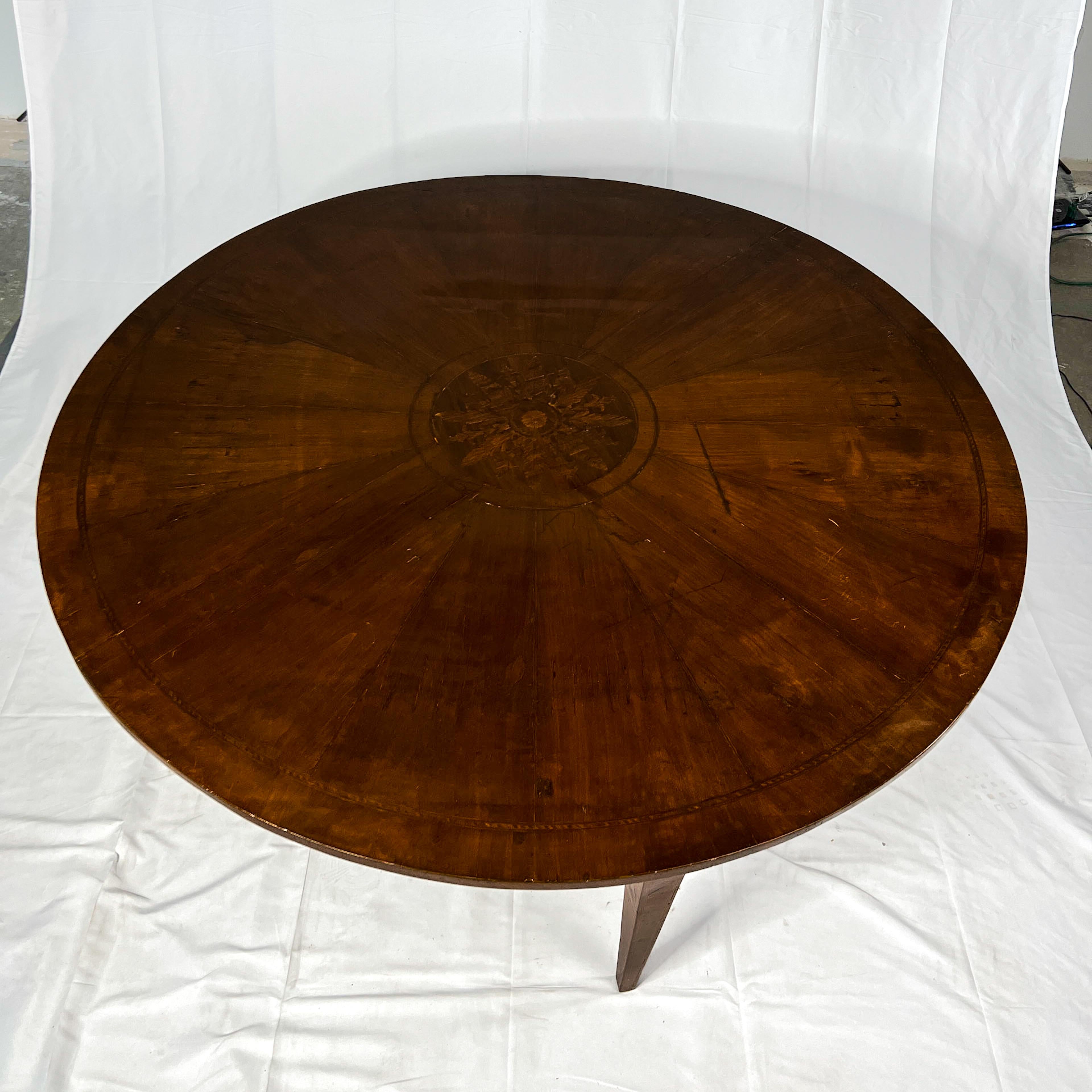 19th c. Italian neoclassical dining table with marquetry detail on the top surface. The four straight tapered legs and the apron also have inlay and stringing detail.
