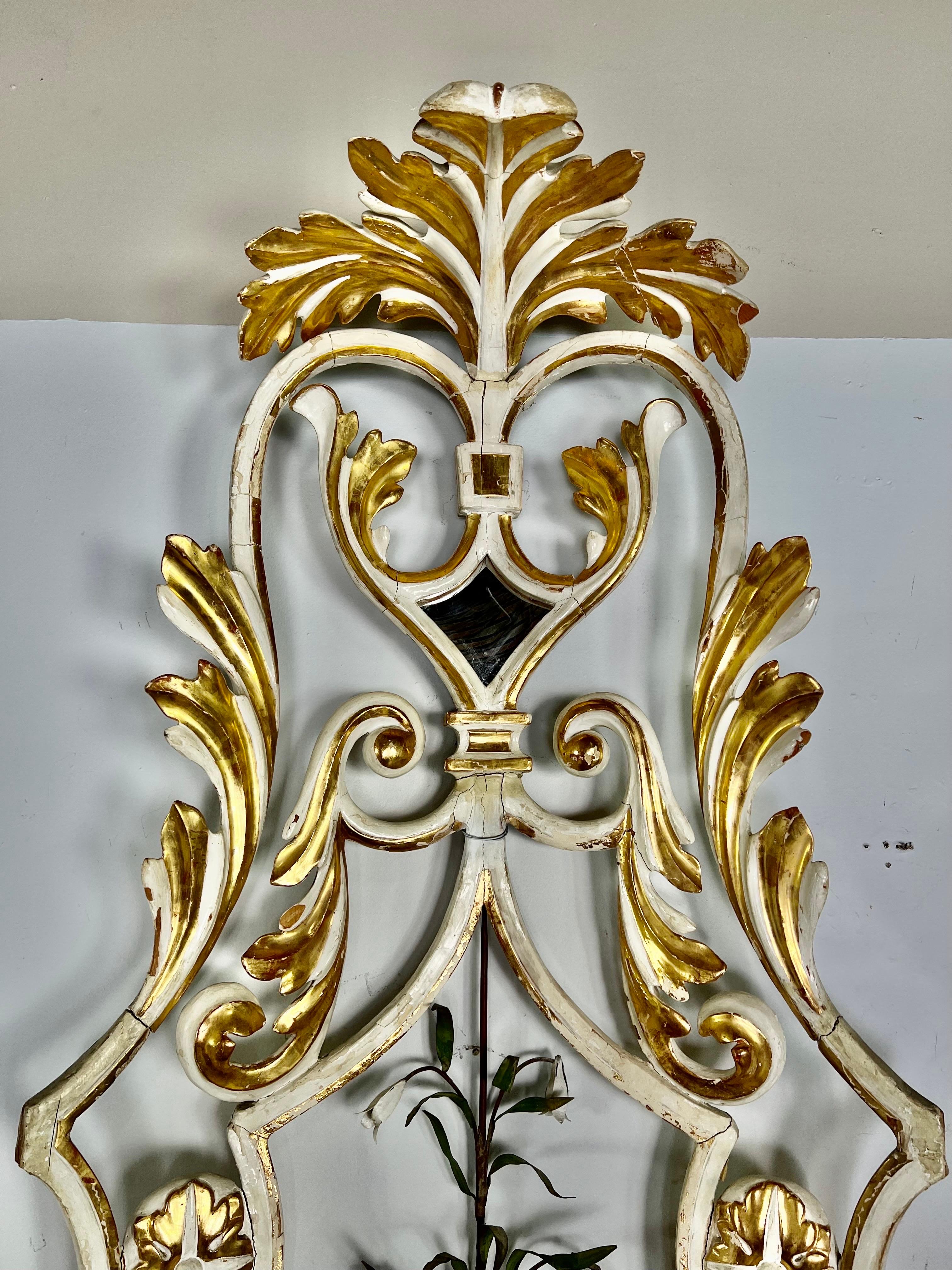 Geschnitztes, bemaltes und paketvergoldetes architektonisches Element aus dem 19. Jahrhundert. Das Stück ist in antikem Weiß bemalt und mit 22 Karat Blattgolddetails versehen. In der Mitte des Elements befindet sich auch ein Blumenstiel aus Metall,