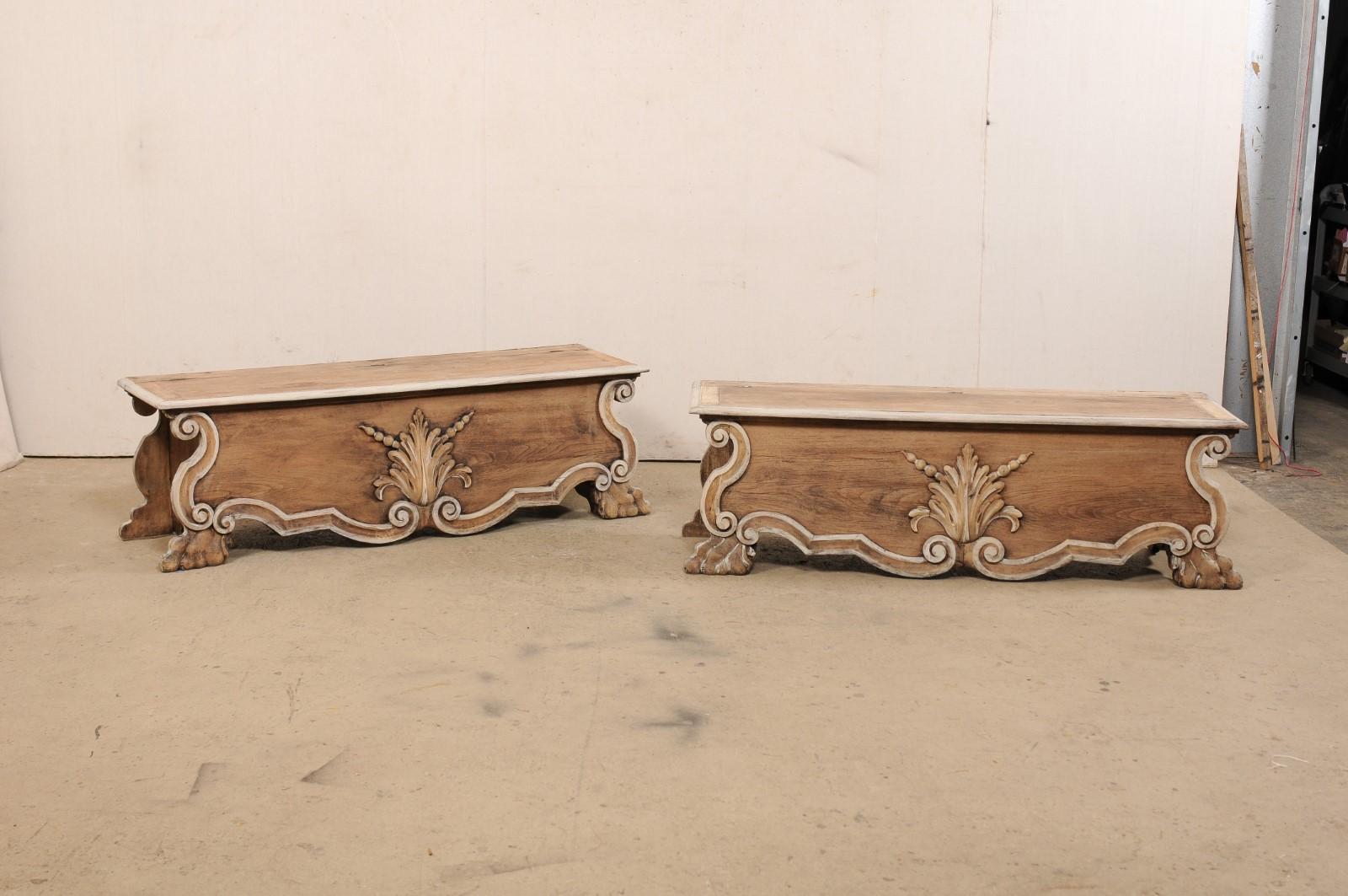 An Italian pair of Baroque-style carved-wood benches with storage from the 19th century. This antique pair of wood benches from Italy are each designed with Baroque influences with the rectangular-seat top overhanging a case below with shell carved