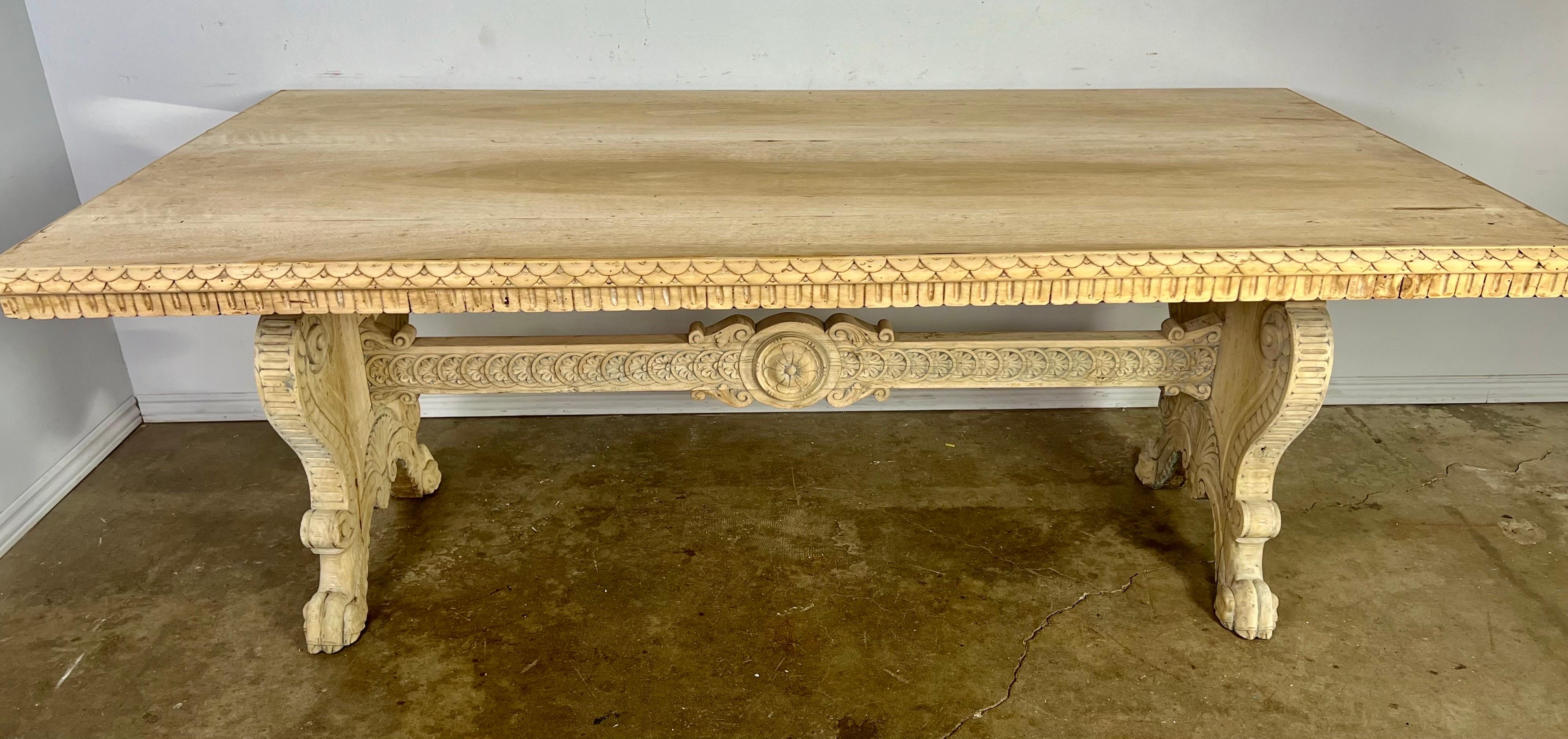19th C. Italian carved trestle table. A large rectangular top sits on two lyre shaped carved pedestal bases that are connected by a center stretcher. Lion paw carved feet.