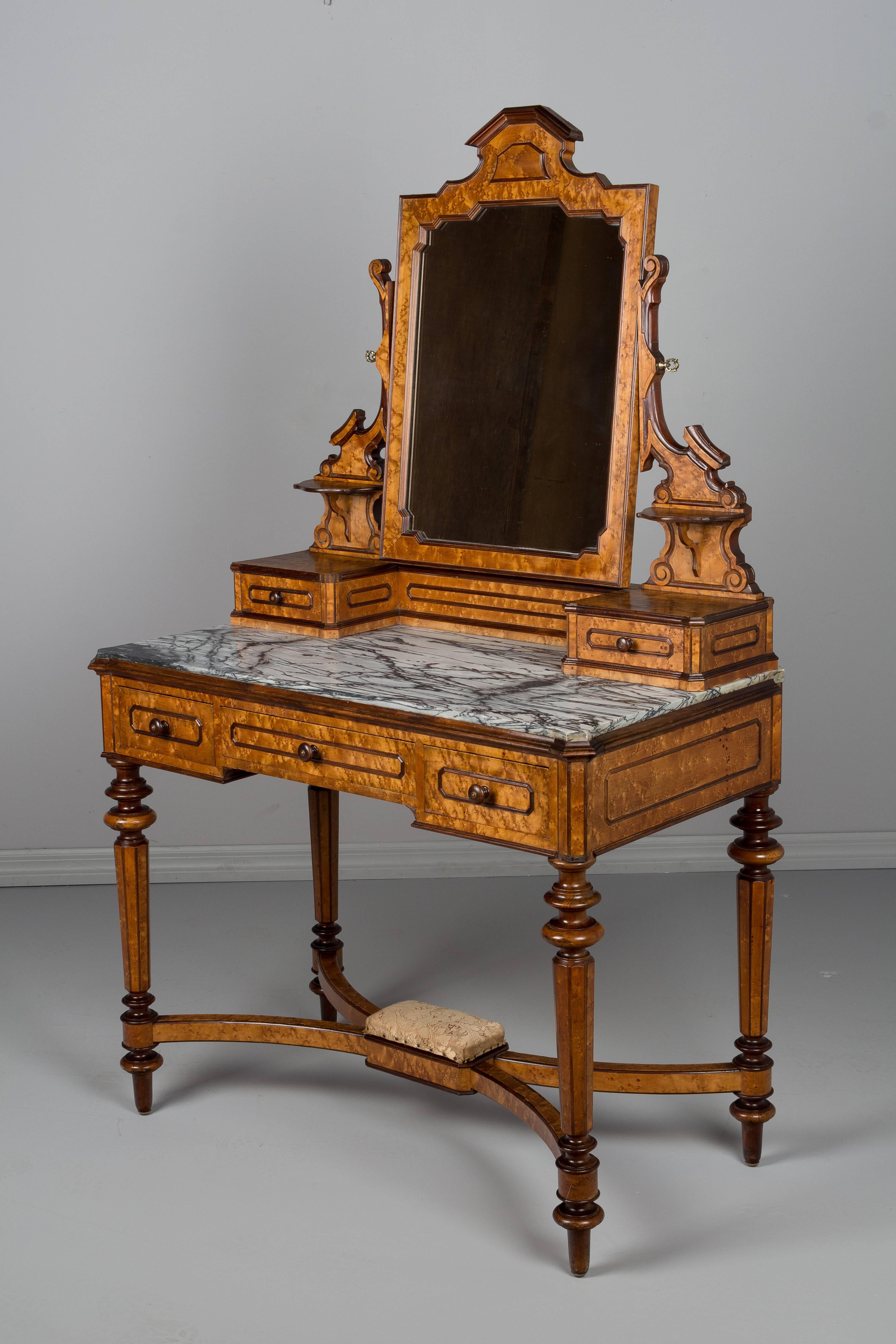 A fine 19th century Italian vanity with pivoting mirror and five dovetailed drawers. Made of solid mahogany and veneer of bird's-eye maple. Original grey veined marble top. Turned legs and stretcher with brocade upholstered foot rest. Manufacture's