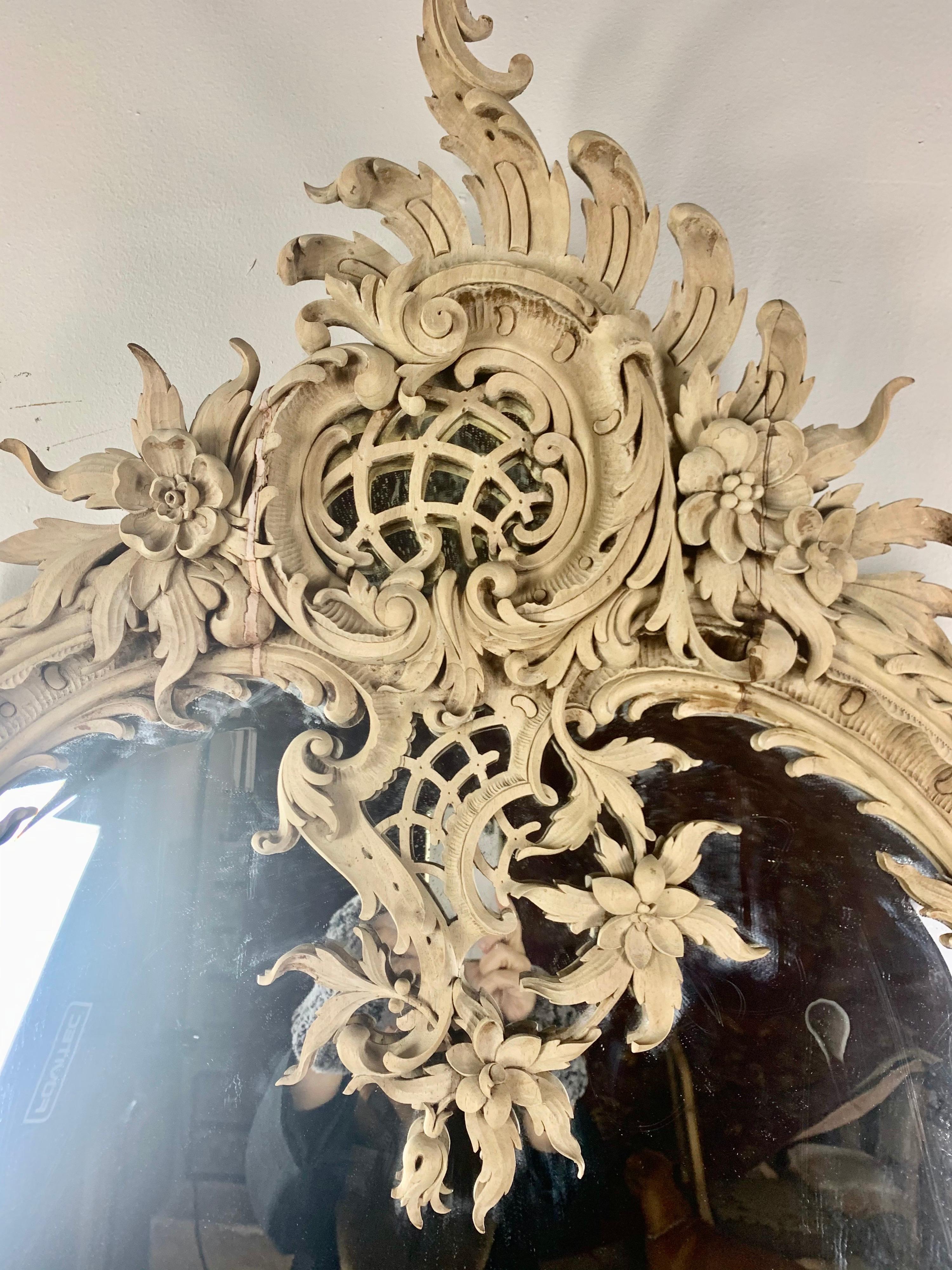 Italian carved natural wood mirror with intricate carved details throughout. The details include carved roses, acanthus leaves and so much more.