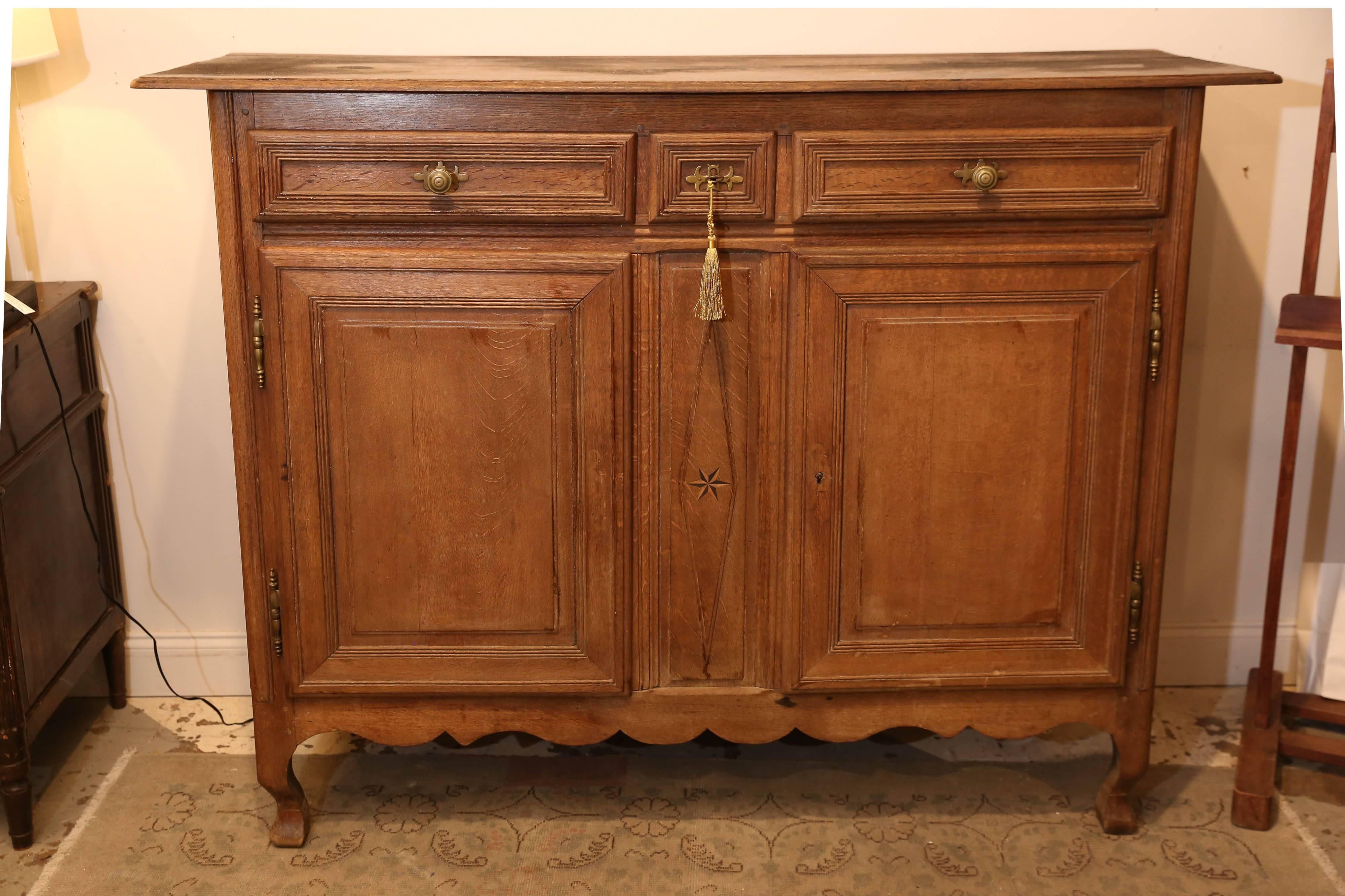 Uncovered while visiting a sweet antique dealer friend's cafe while in Flanders, Belgium, this large wood buffet features wonderful brass hardware and an inlaid star at center along with a scalloped skirt and curved legs. There are three upper
