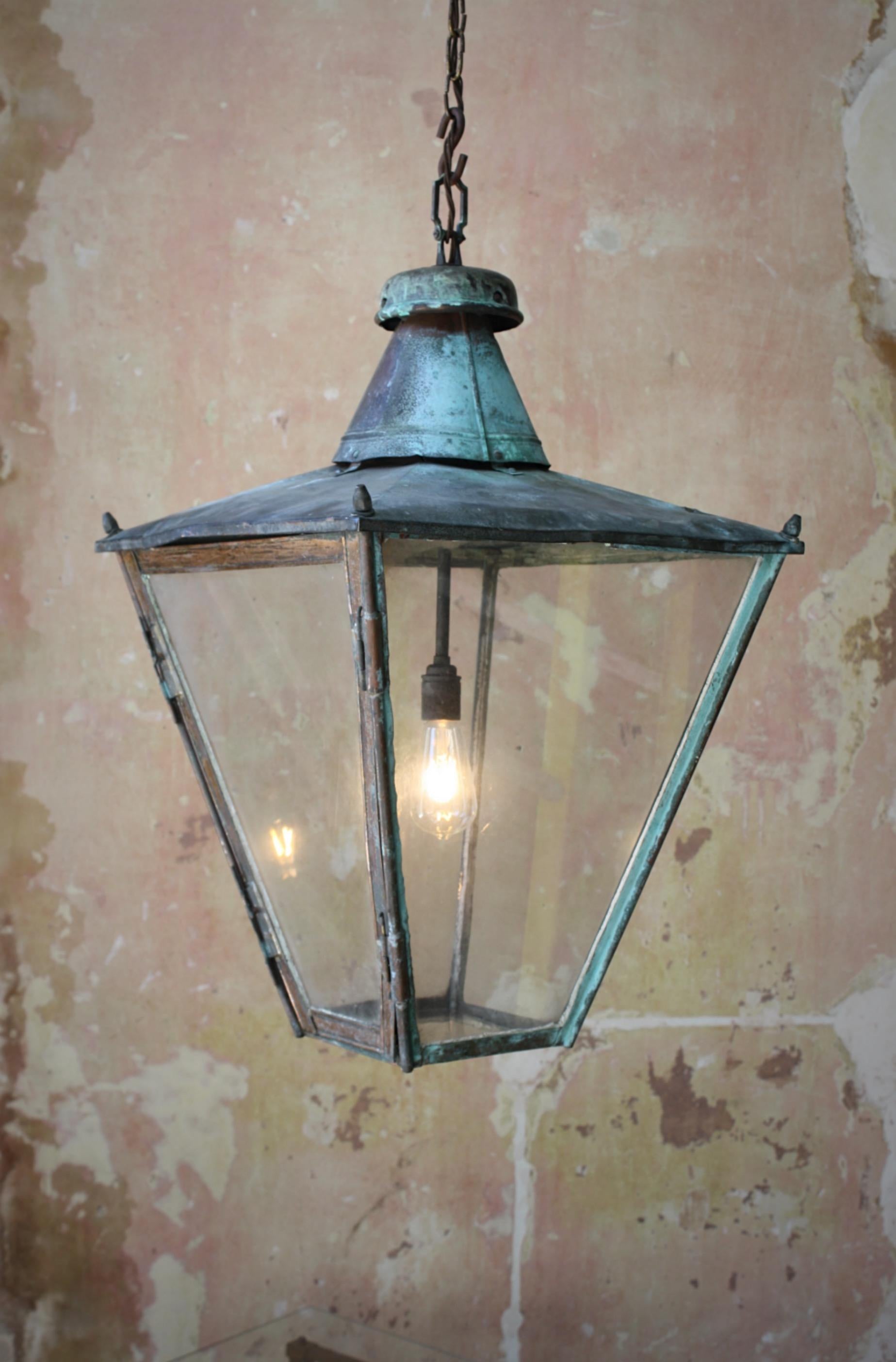A larger than the norm, glazed and sheet copper hanging lantern with a natural verdigris finish.

Victorian with age related wear, marks, dings and dents. 

Measures: 83cm in drop, 48cm in depth & width.

Original chain length with the s hook