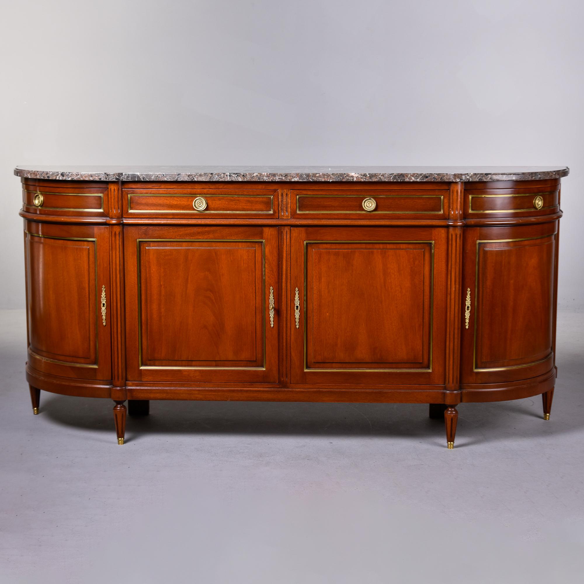 Found in France, this Louis Philippe mahogany and marble sideboard dates from the 1860s. Bow front cabinet with four drawers over four hinged cabinet doors. Marble top has a beveled edge and is a taupey shade of brown with streaks of cream, gray,