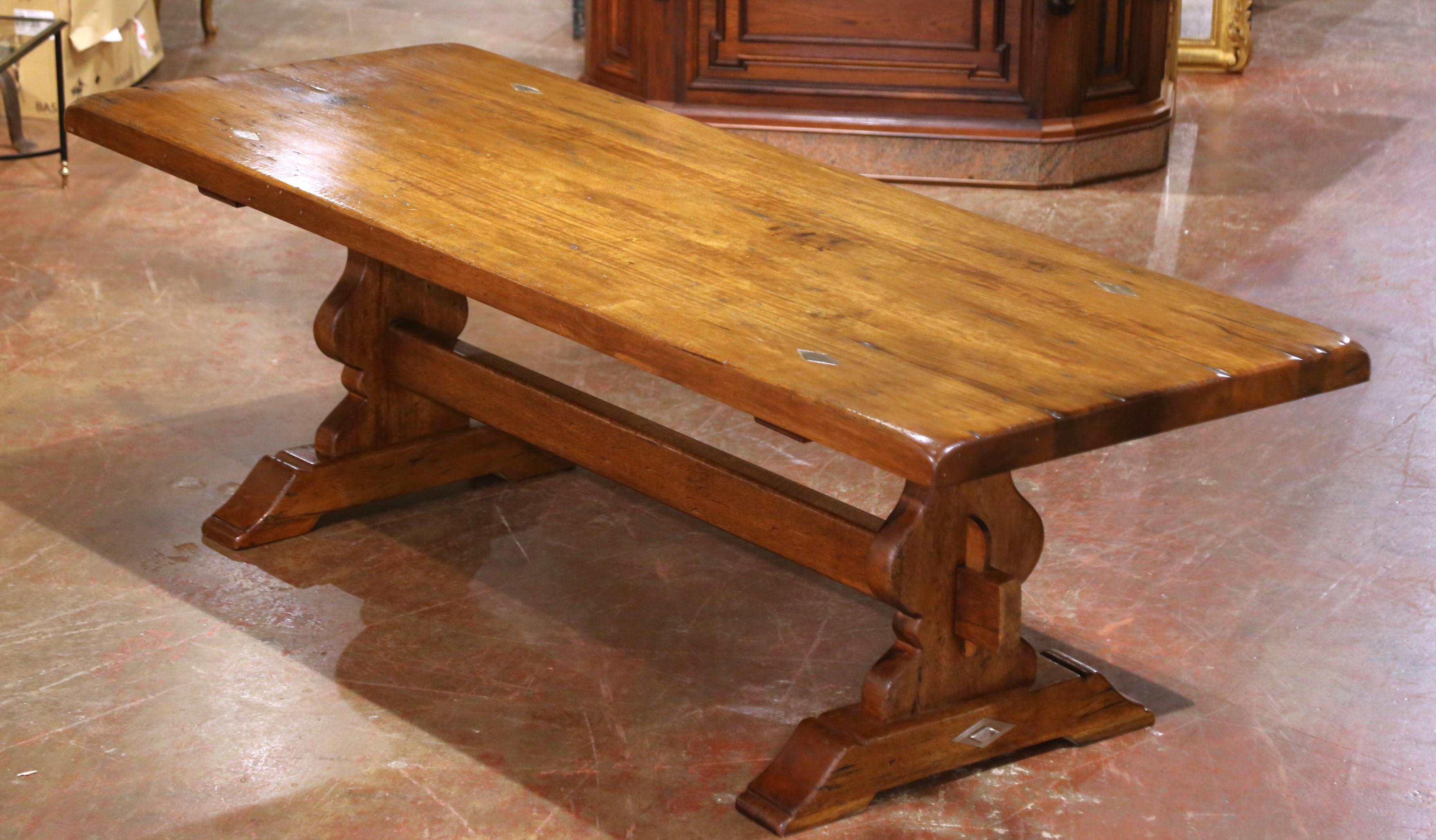 This impressive antique refectory table was crafted in France circa 1890. Built from solid walnut wood, the substantial three-inch-thick top is pegged and accented with diamond-form metal inlays, adding both visual interest and structural integrity.