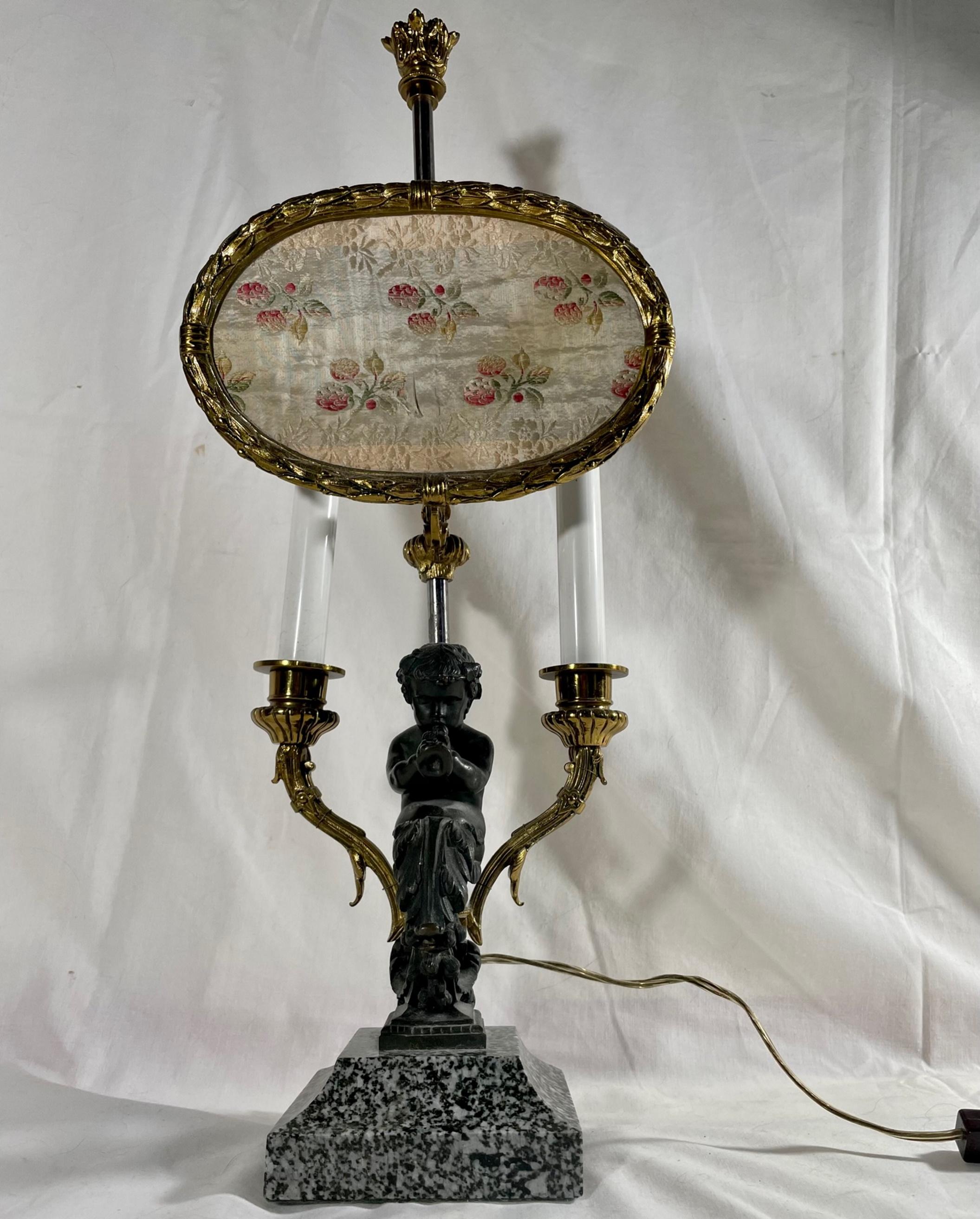 19th Century Louis XV Style Bronze Two Light Table Lamp with Adjustable “Pare-feu“.

Elegant late 19th century Louis XV style table lamp with adjustable screen. It is made with a high level of refinement in casting and chasing the bronze figure.