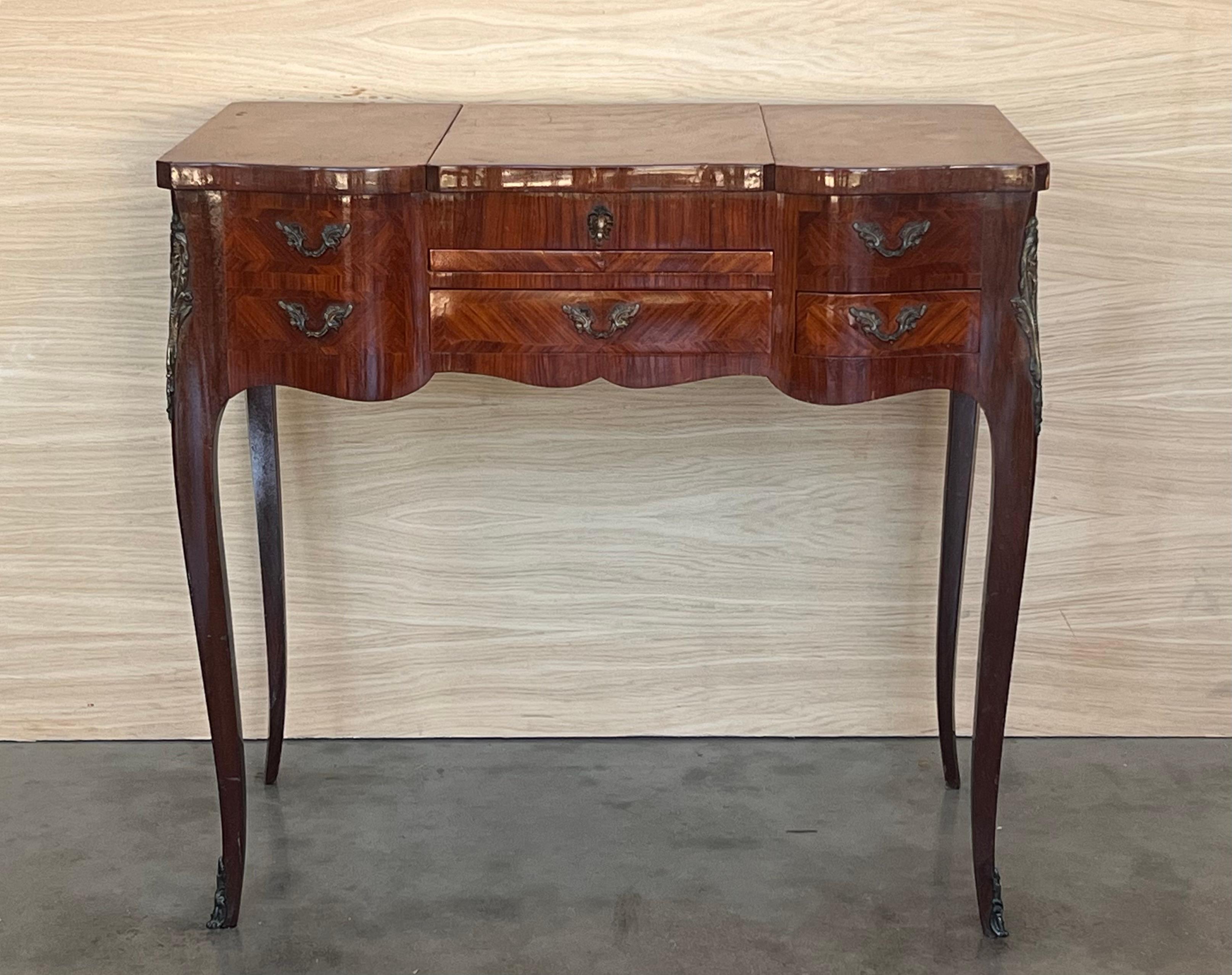 Tocador francés Luis XV del siglo XIX, poudreuse o coiffeuse que se alza sobre cuatro esbeltas patas cabriolé ahusadas. La parte superior está dividida en tres paneles enmarcados en parquetería y decorados con elaborada parquetería espejada; la