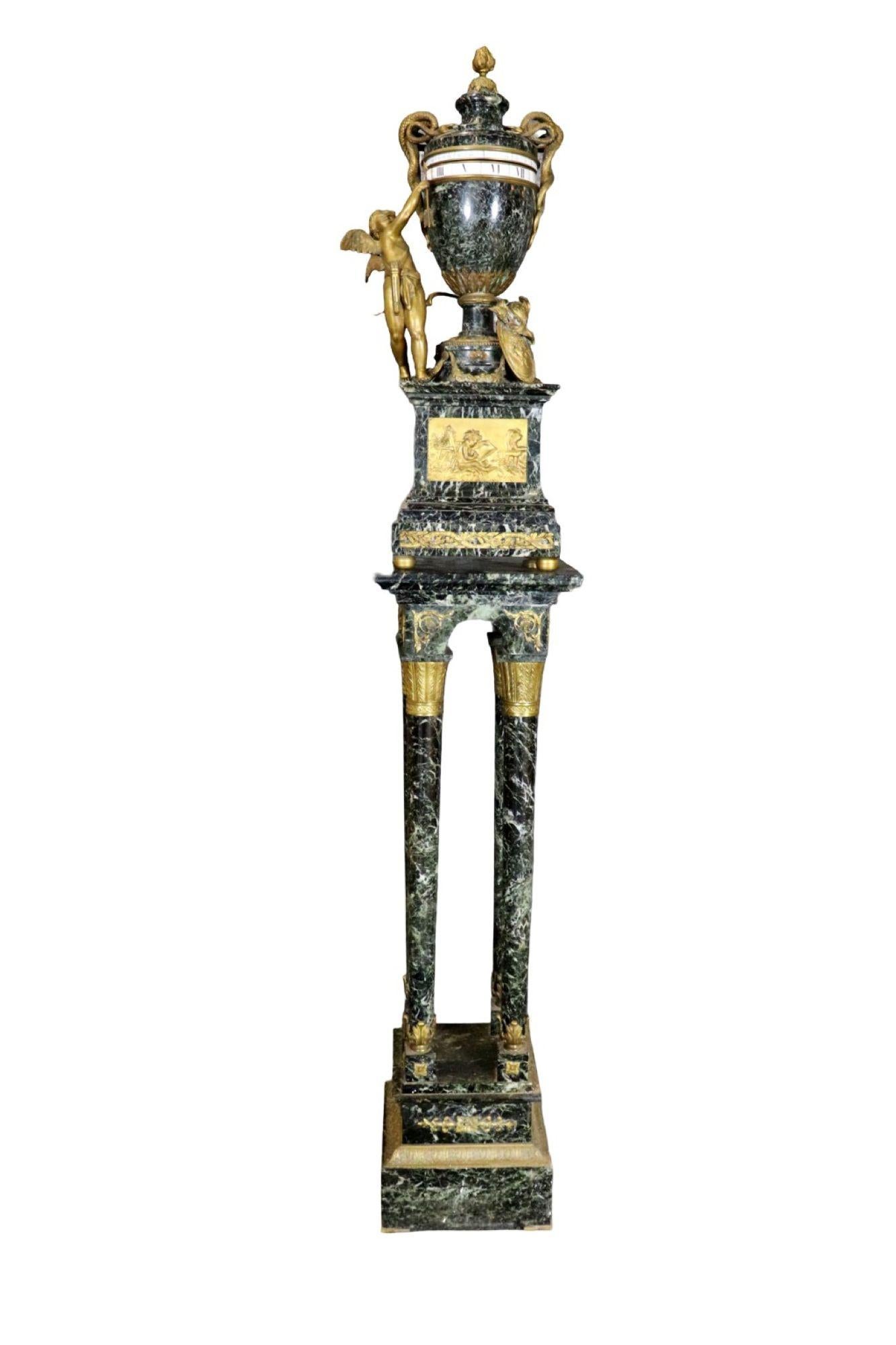 
19th C. French Rotary Clock.  Ormolu Mounted and Verde Antico marble rotary mantel clock on Pedestal. A fine large Louis XVI style gilt bronze mounted and verde antico marble rotary mantel clock.  The urn embellished with serpent handles, a putto