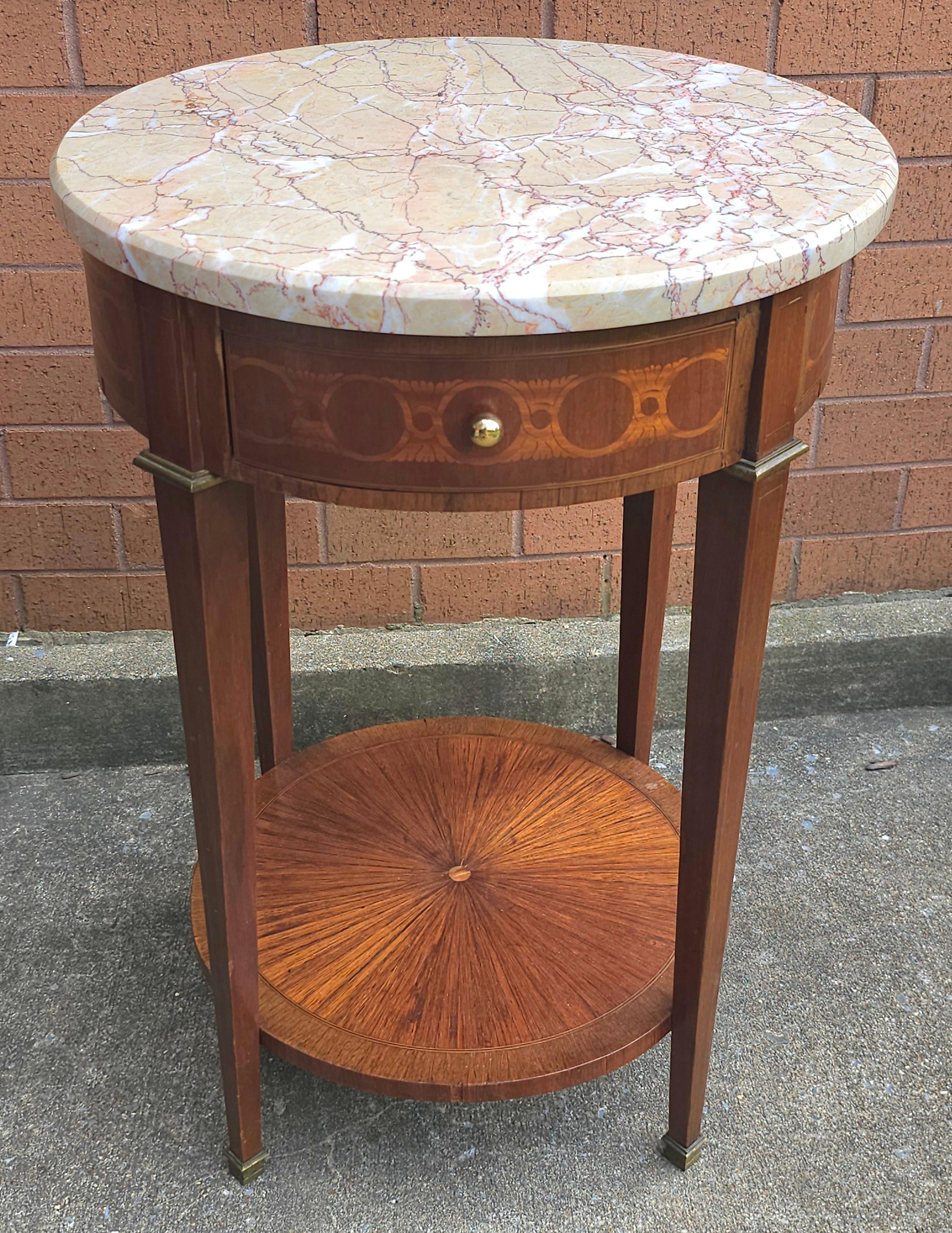 Un 19e siècle  Table d'appoint en acajou marqueté de style Louis XVI, avec des ferrures en laiton sur un pied fuselé et un plateau en marbre vénitien très riche. 