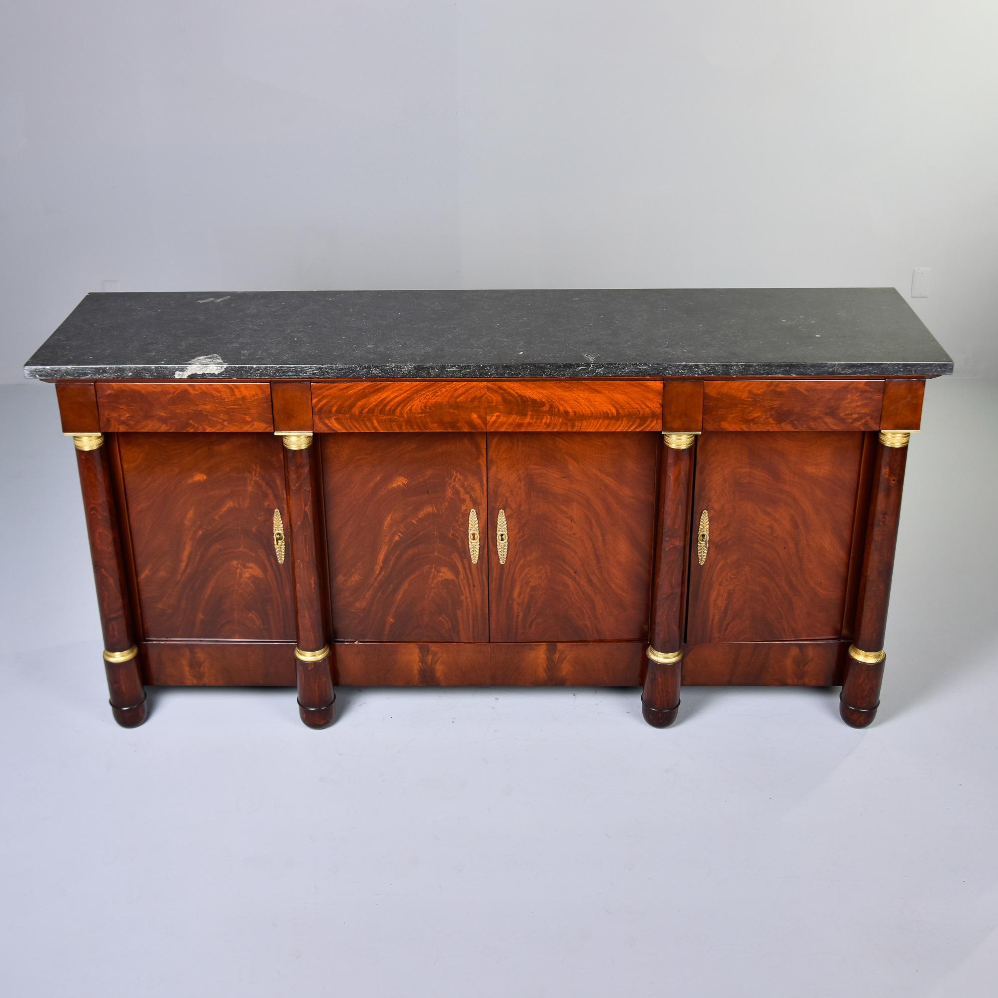 Found in France, this Louis XVI style cabinet dates from the late 19th century. Cabinet features a flame mahogany base with a black marble top, three drawers over three storage compartments. Center compartment has double, hinged locking doors with