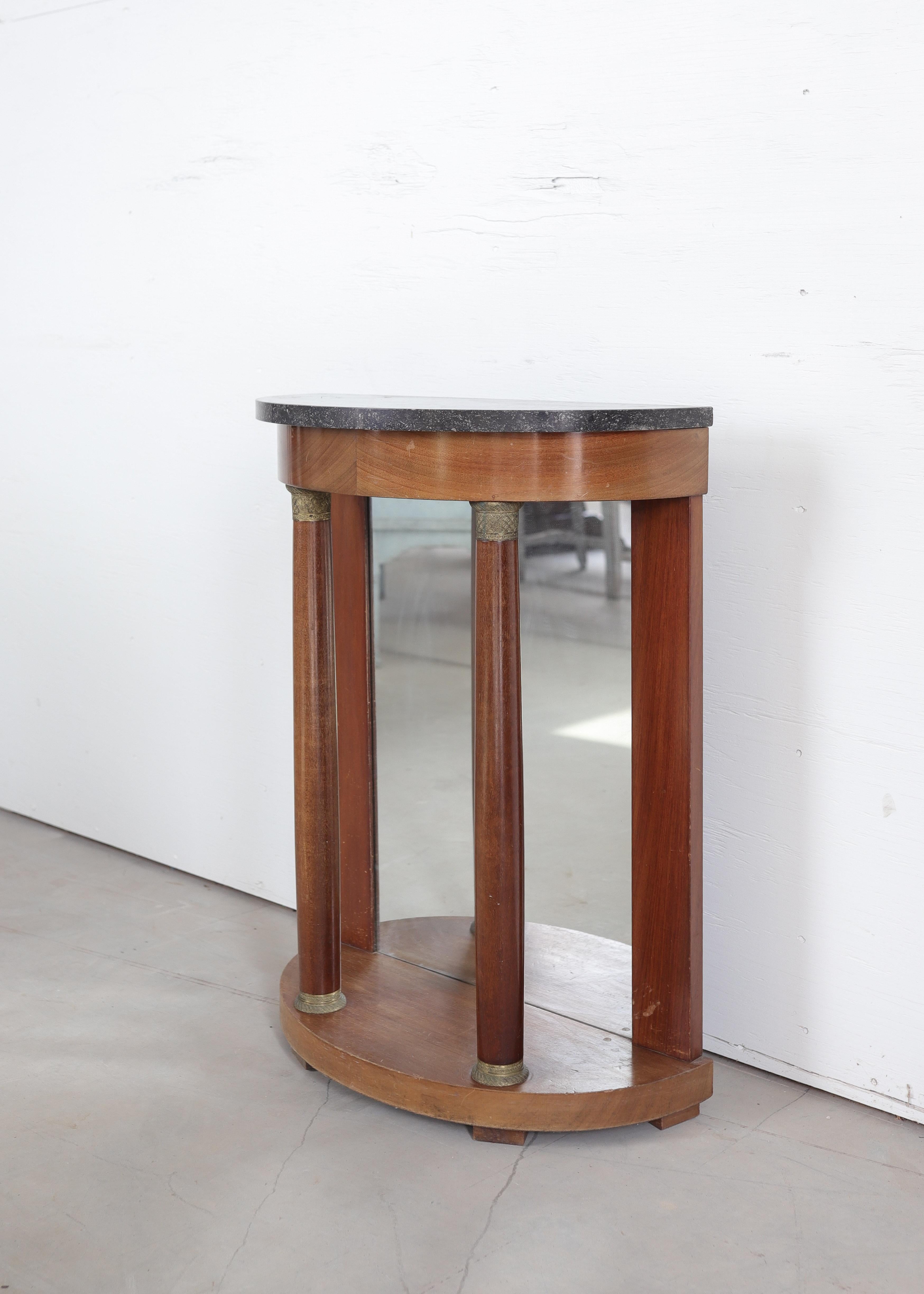 Une élégante console française du XIXe siècle en acajou riche, présentant une forme gracieuse en demi-lune et un équilibre néoclassique raffiné. Le plateau de la console est façonné dans un marbre gris foncé subtilement veiné, ajoutant un contraste