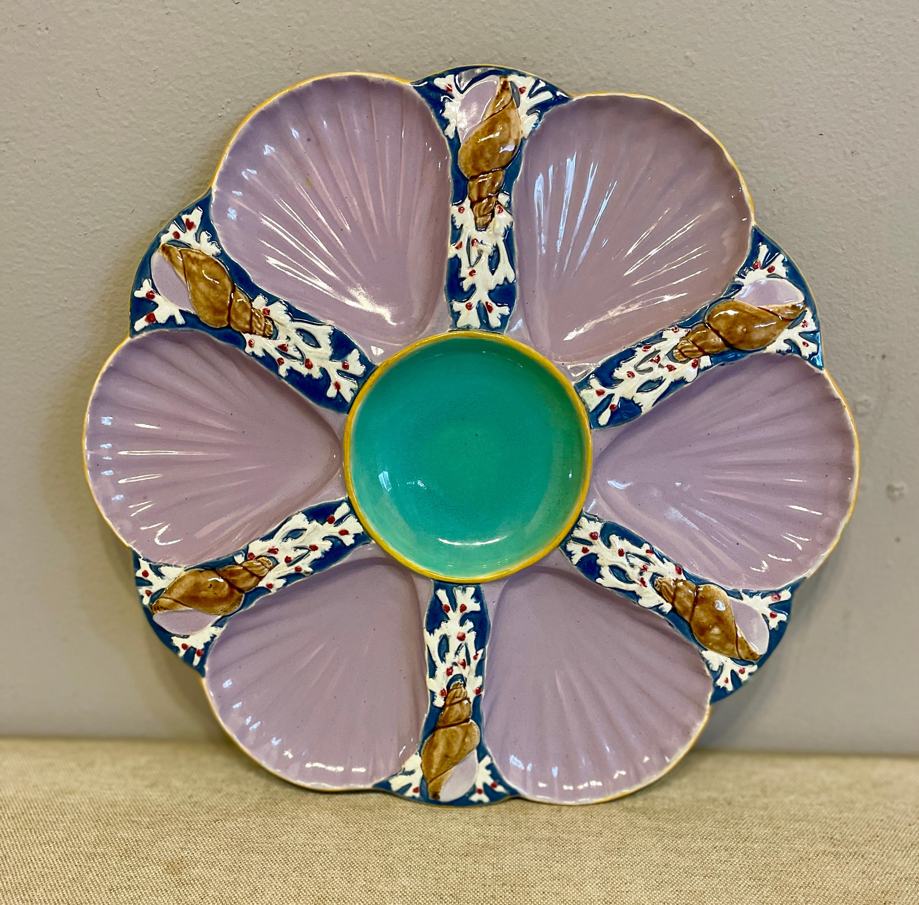 A beautiful six well Majolica oyster plate glazed in lavender with a deep turquoise central well, each separated with coral and seashell from the factory of Holdcroft. No marks on the bottom. All in good condition with no chips, damage or repairs