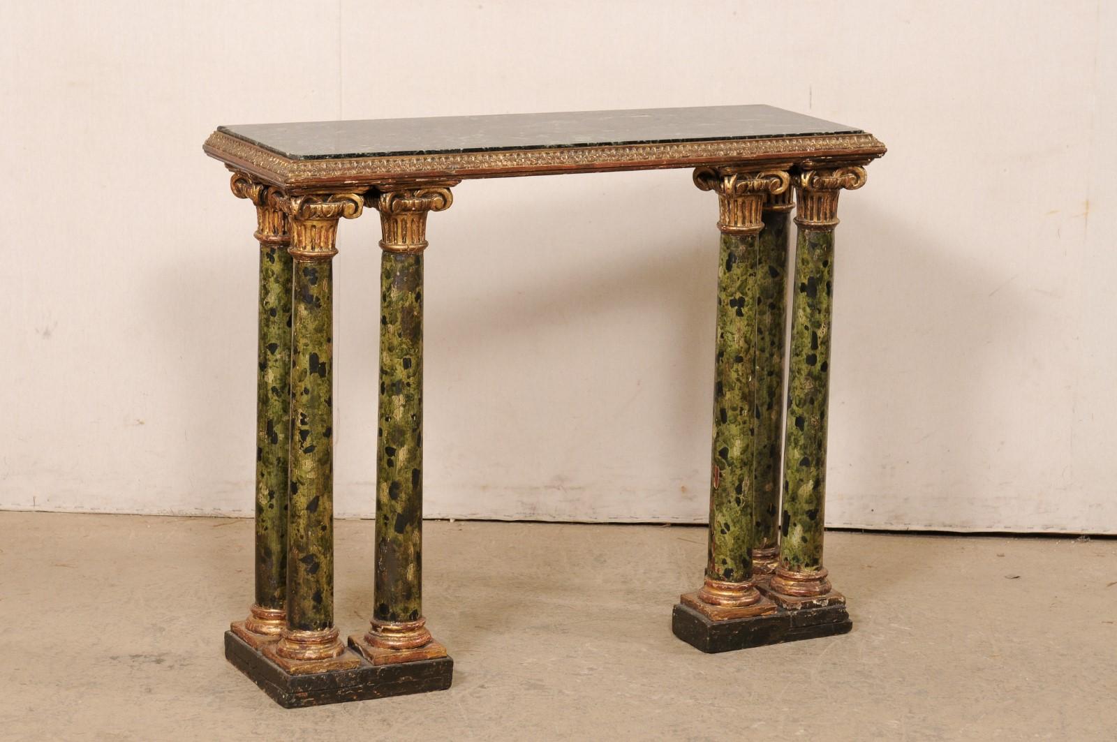 An Italian wall console table with green marble top and column legs from the 19th century. This antique table from Italy features a slender, rectangular-shaped green marble top which is recessed into an elegantly carved lambs tongue frame about its