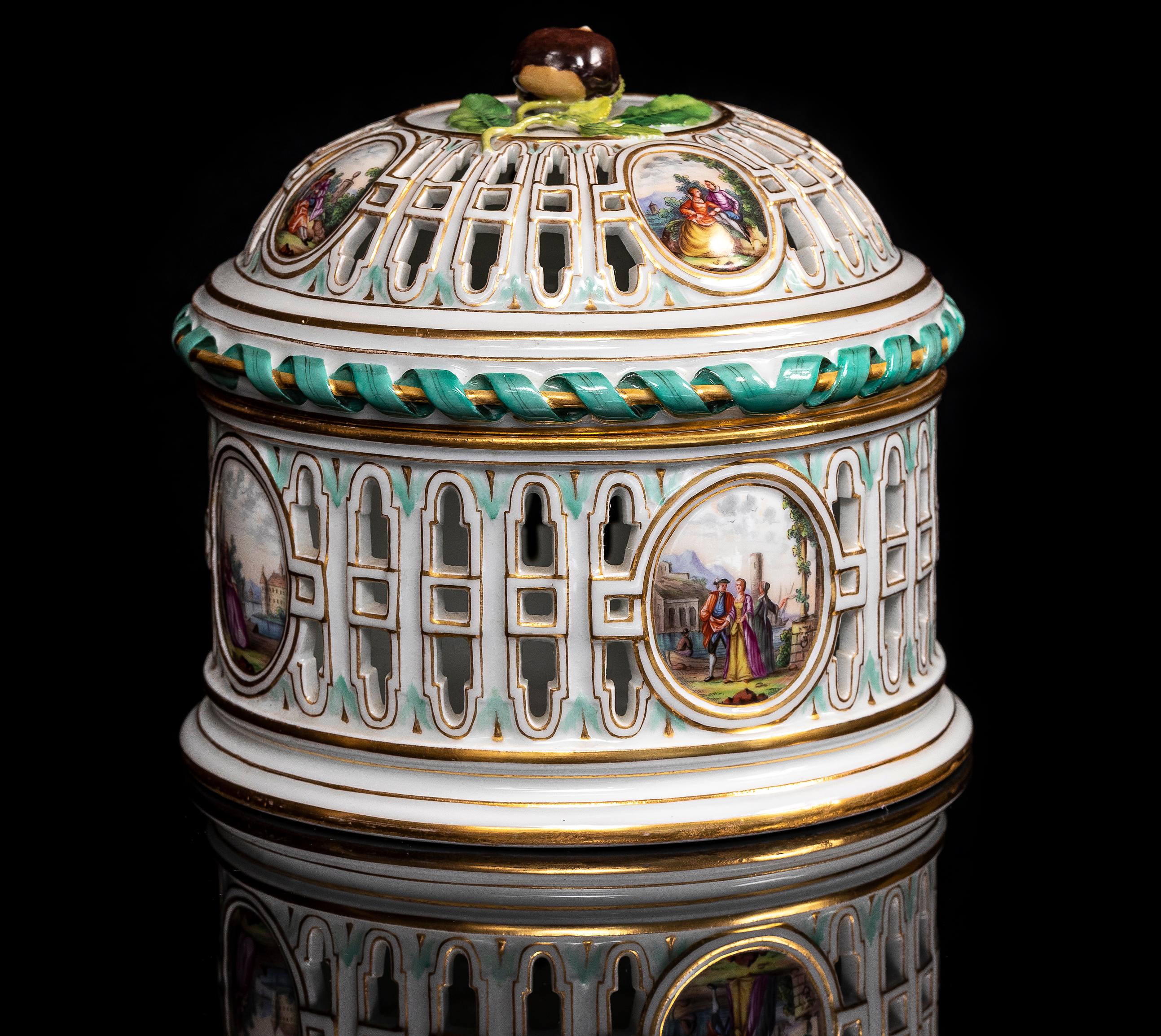 A 19th Century Meissen Porcelain Covered Openwork Filigree Centerpiece with Watteau Cartouches and Village Scene Cartouches.
 This 19th-century Meissen porcelain covered centerpiece features an elaborate openwork filigree structure, resembling