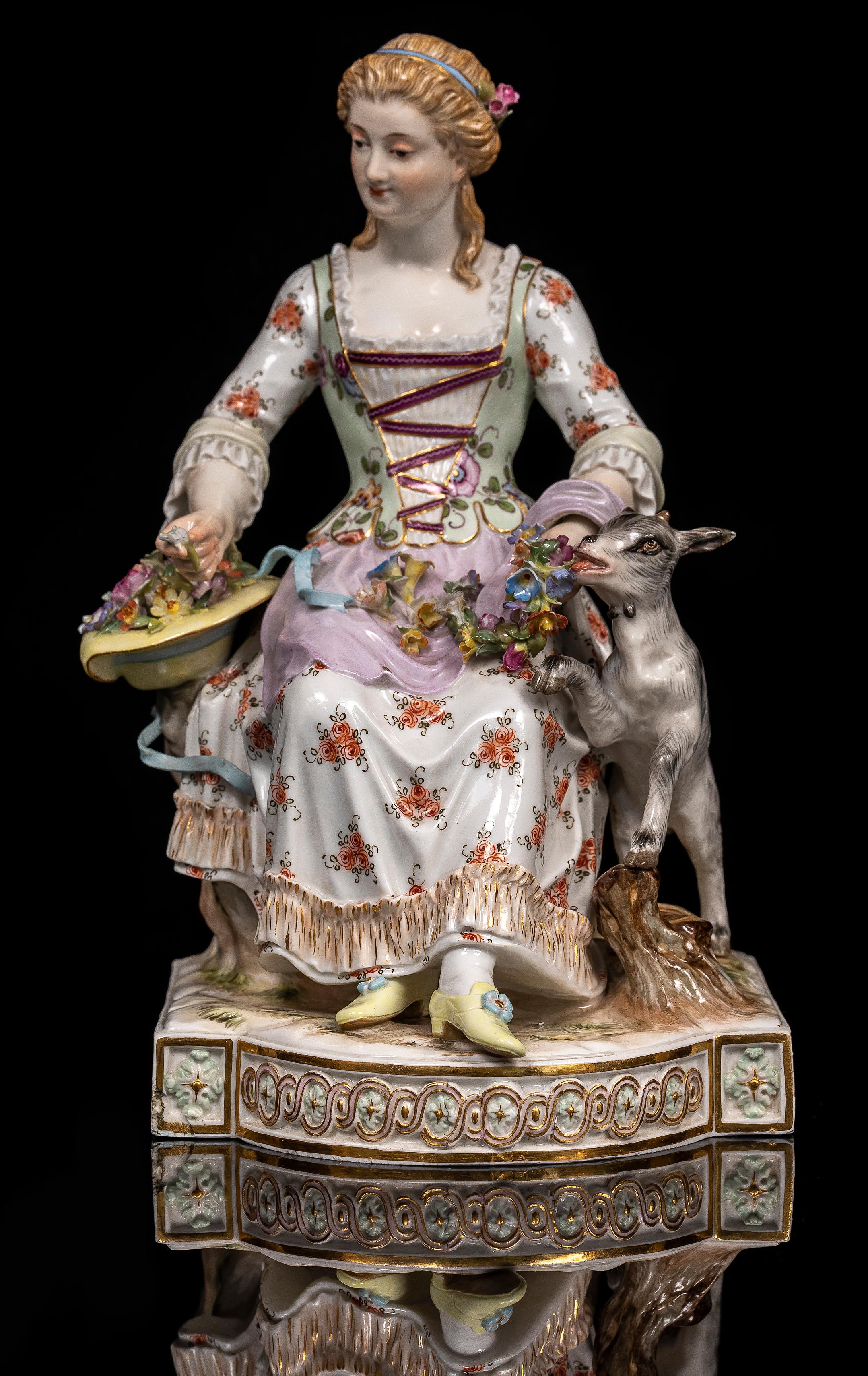 Grupo de porcelana de Meissen del siglo XIX de una mujer sentada con un cuenco de flores y una cabra como mascota.  Este grupo de Meissen, finamente detallado, representa a una joven sentada sobre una base naturalista, adornada con volutas de