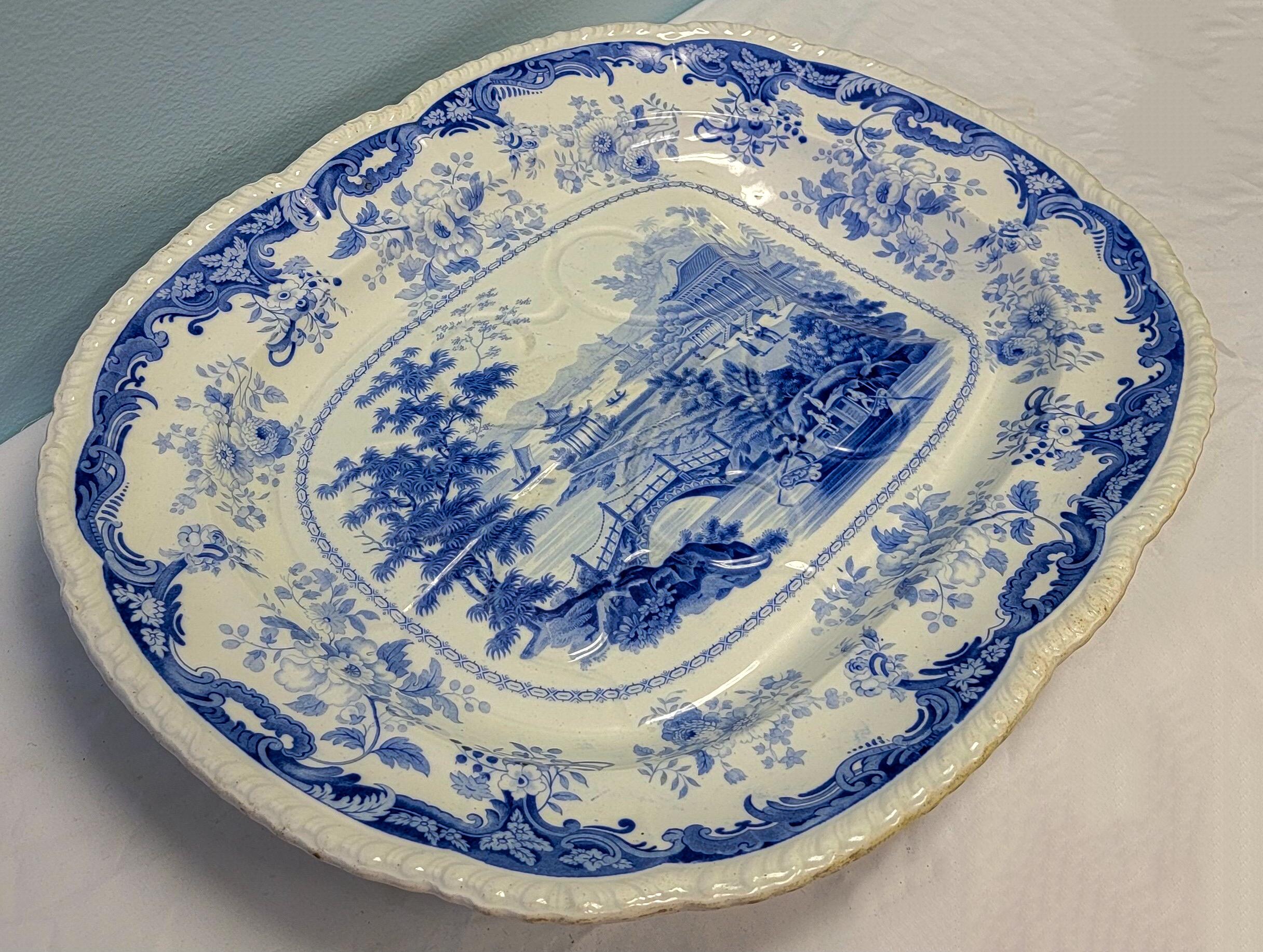 This is a very large Minton Chinese marine opaque blue and white transferware platter. It has a lovely pastoral scene. It is footed and has wells. The underside is marked.