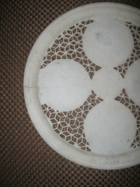 Intricately carved marble plate. Marble is cream colored.