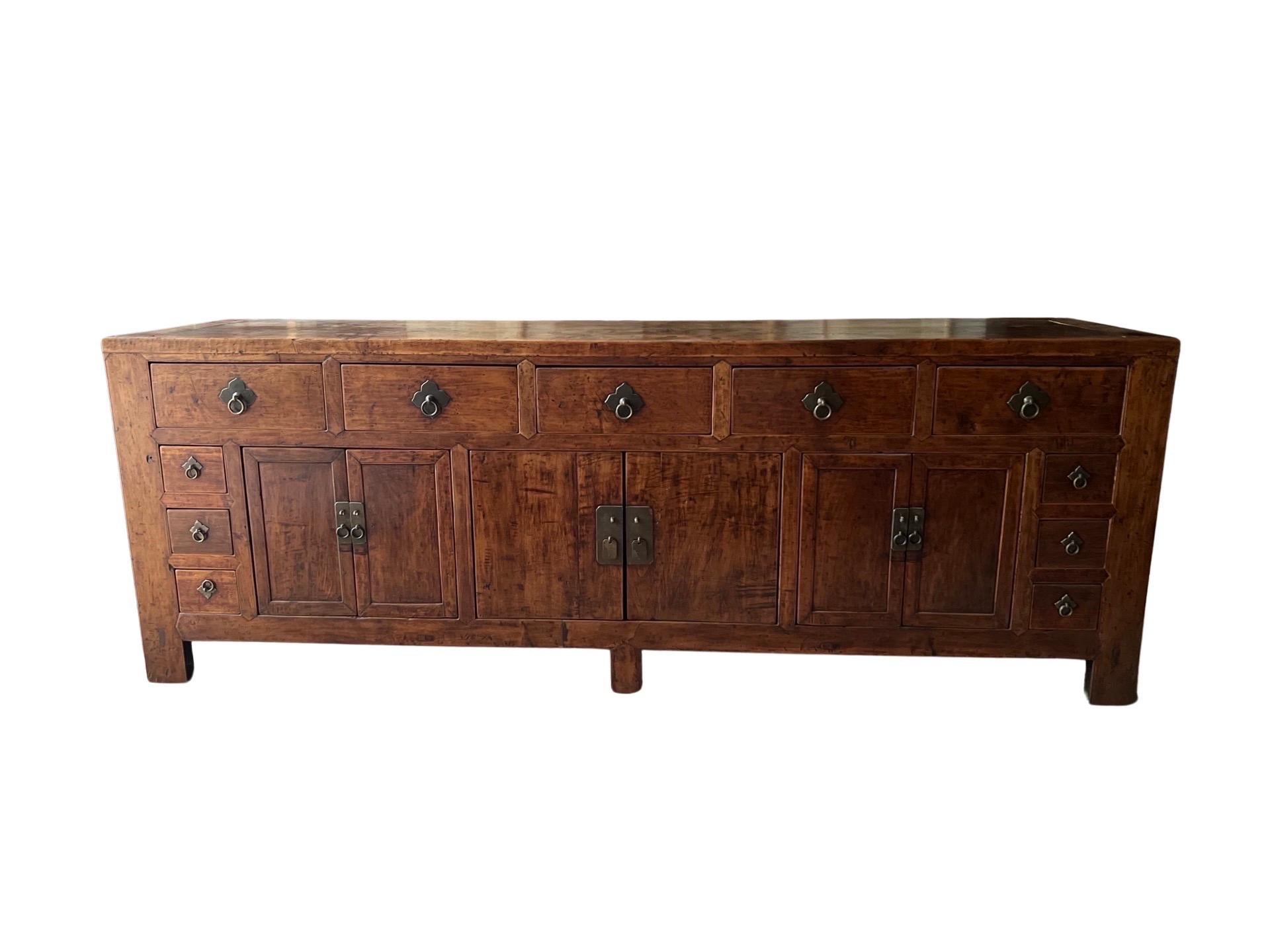 Chinese Origin, 19th century or earlier. 

An exceptional 19th century or earlier Qing Dynasty wooden buffet or sideboard likely made in possibly rosewood or elmwood. This piece is extremely heavy and features not only 5 frieze drawers to the upper