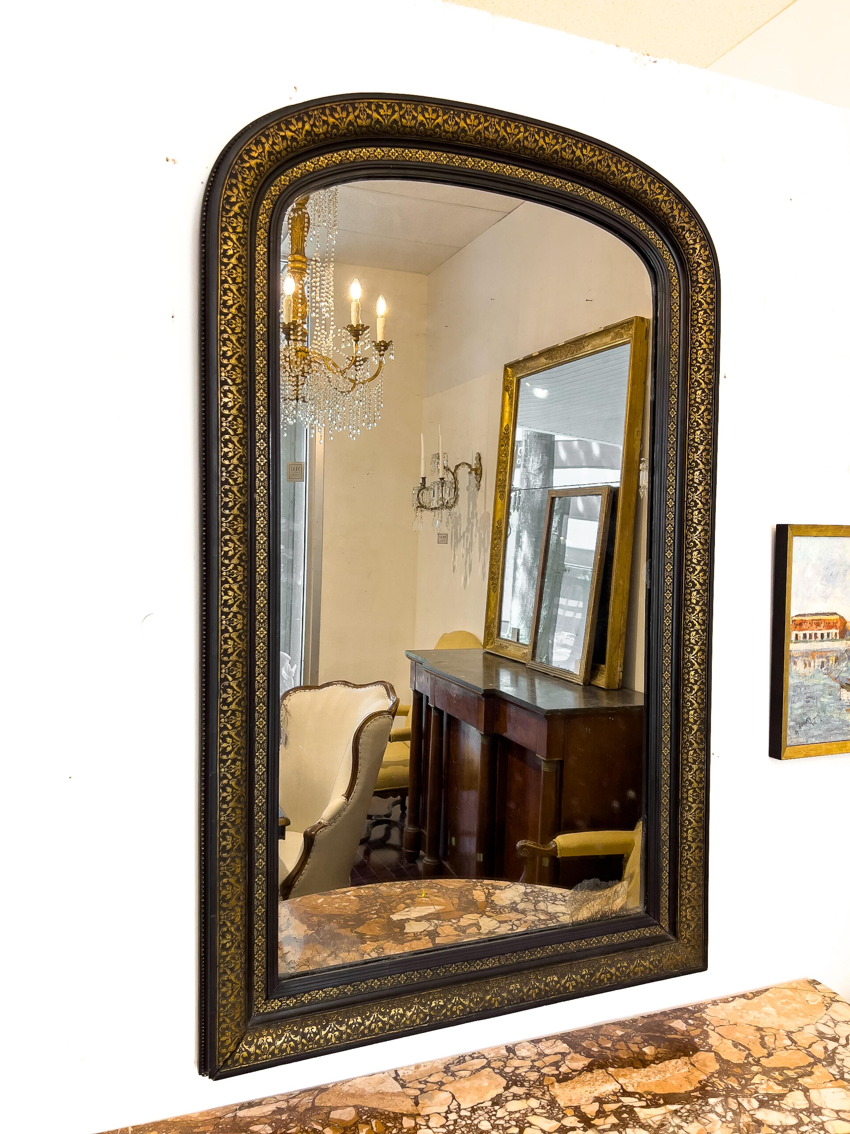 19th Century Napoleon III mirror with black and gilt decoration. It has the original mirror which has dark inclusions and foggy appearance.