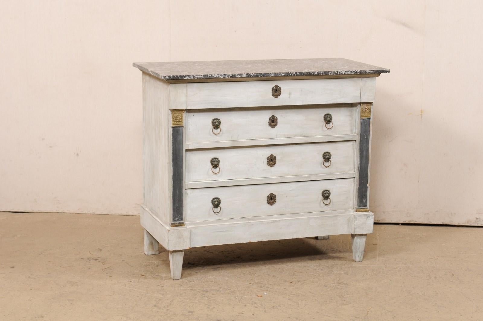 A French four-drawer Neoclassic commode with its original marble top from the 19th century. This antique chest from France retains its original marble top which sits atop a Neoclassical case that has been designed in clean/linear lines, and raised