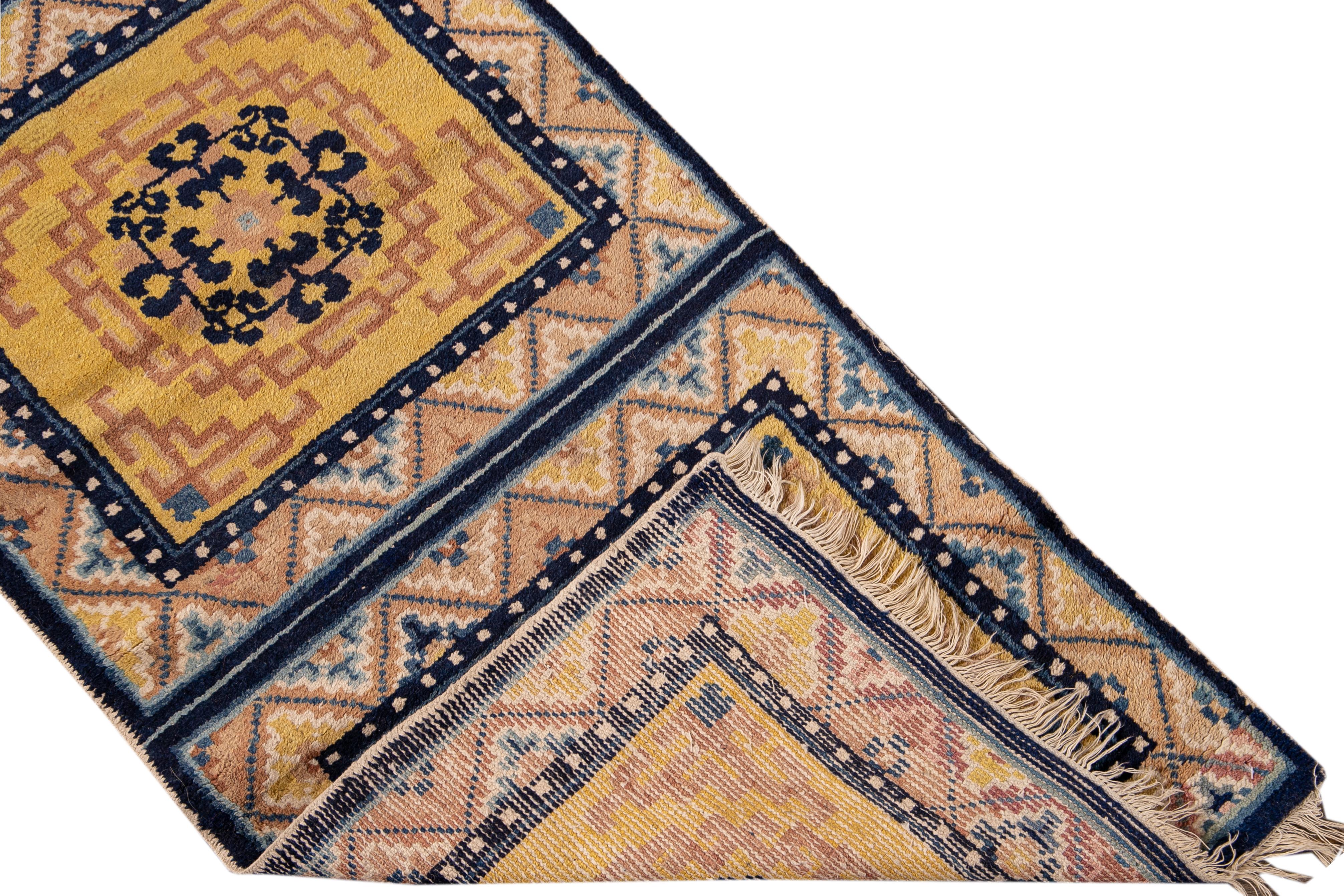 Beautiful antique Ningxia Chinese hand-knotted wool runner with a yellow field. This Chinese runner has a blue frame and accents of brown, yellow, and blue in a gorgeous all-over Chinese medallion floral design. 

This rug measures: 2' x 11'4