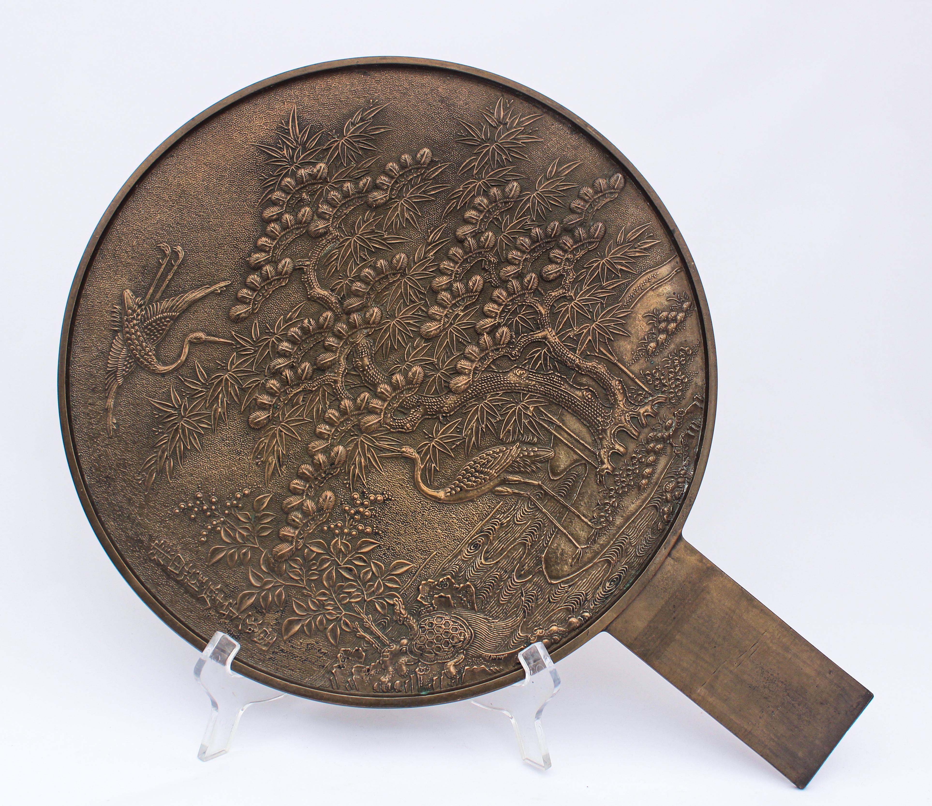 Antique traditional Oriental bronze Japanese Kagami handled Mirror. 
An exceptional and stunning Japanese bronze handled mirror called Kagami.
Large and heavy bronze handle mirror polished to one side with the other side moulded in relief.
The